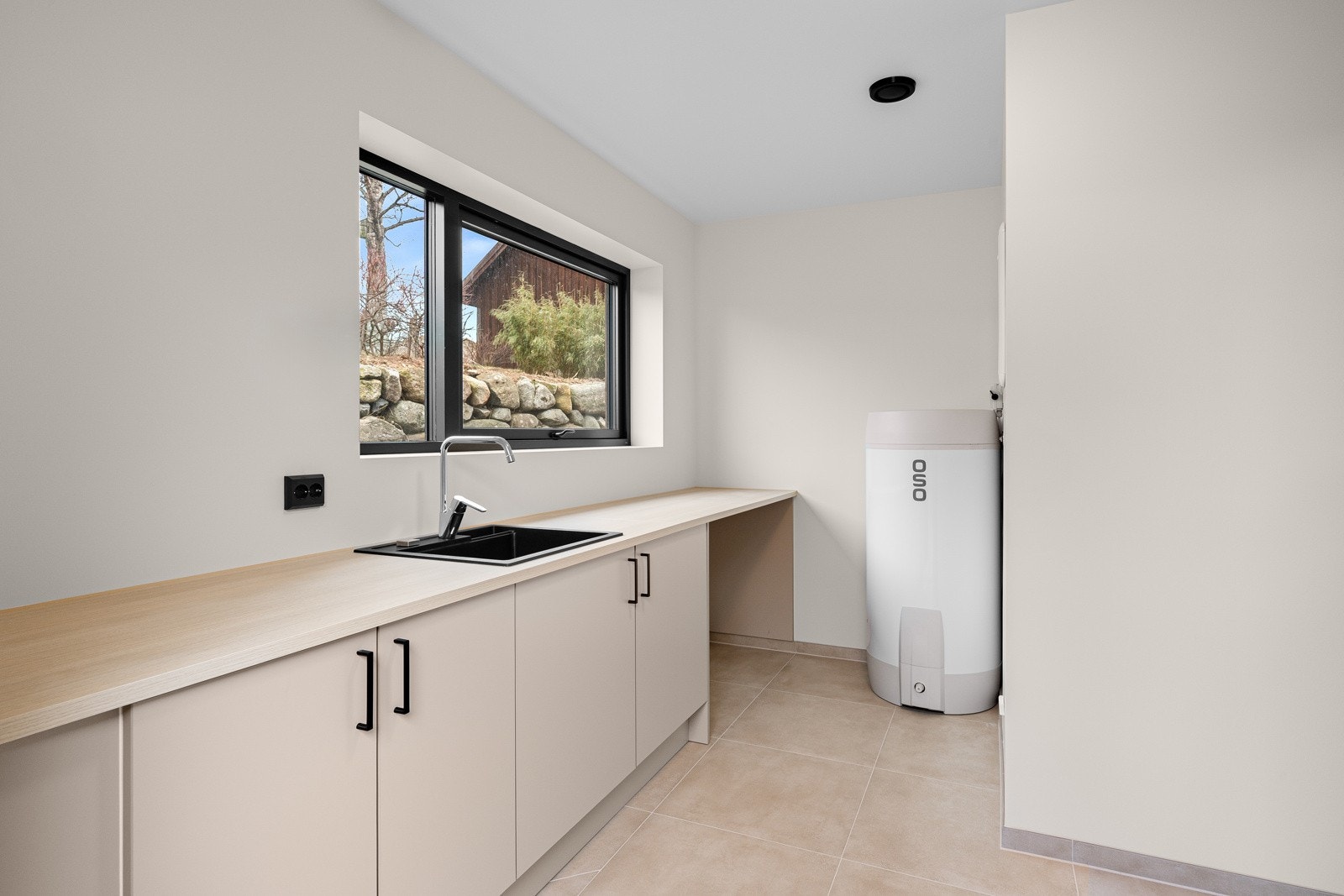 Vaskerommet er en funksjonell og romslig plass som gjør hverdagslige gjøremål lettere og mer effektive. Her finner du god benkeplass til sortering og folding av klær. Galleribilde