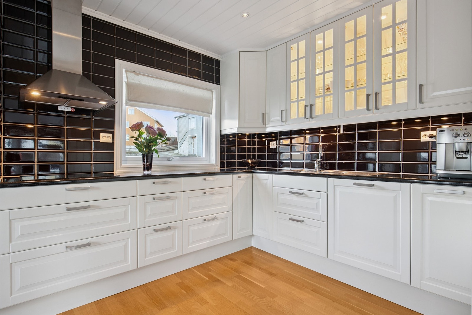 Pent kjøkken i hvit utførelse. Benkeplate i stein Galleribilde