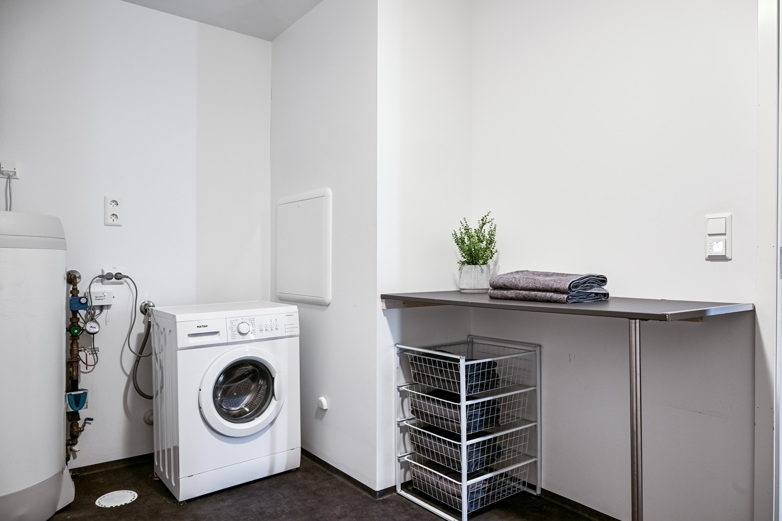 Romslig vaskerom med gode arbeidsflater og oppbevaringsmuligheter, en praktisk løsning i en travel hverdag Galleribilde