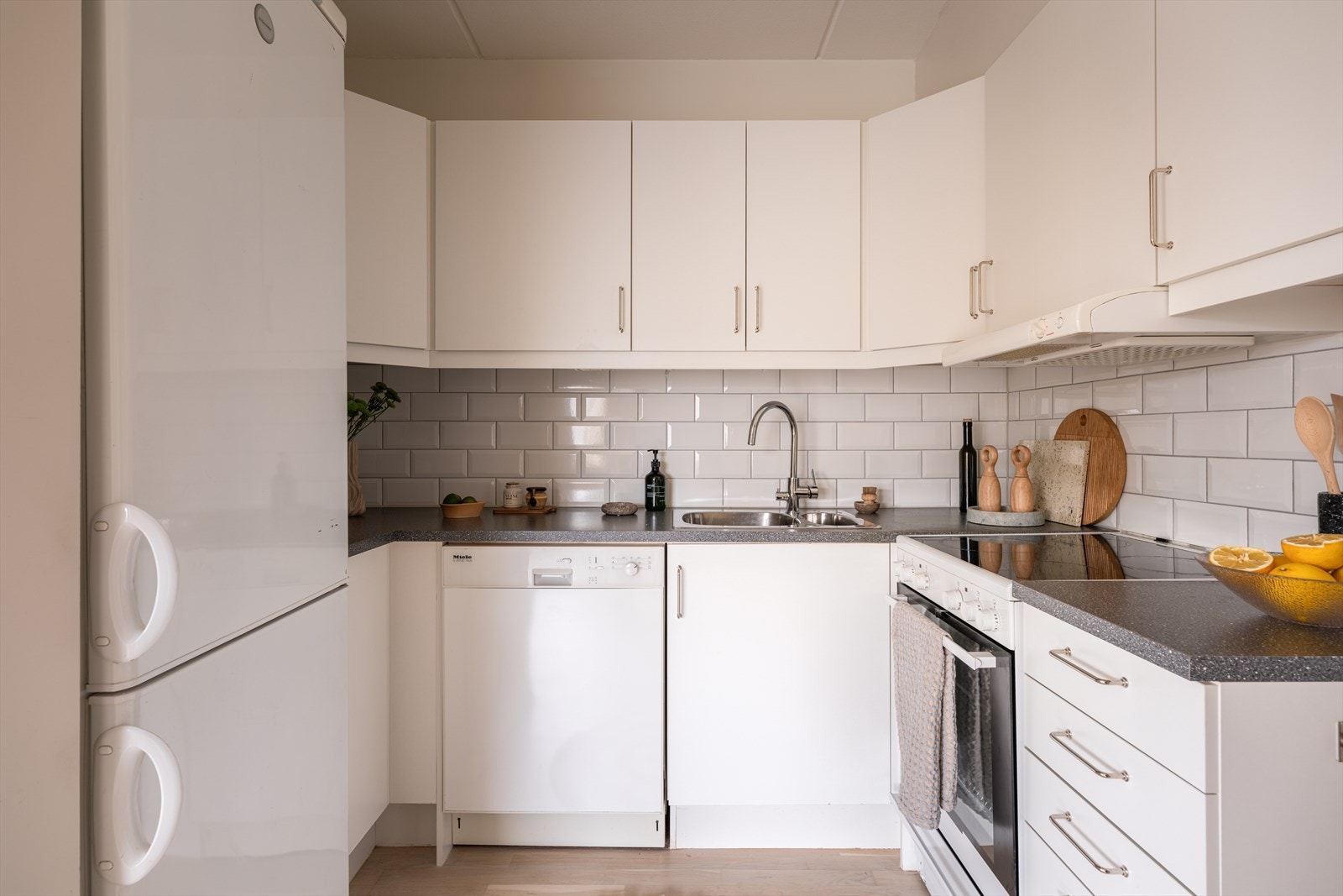 Kjøkkenet har fliser på veggen mellom over- og underskap. Galleribilde