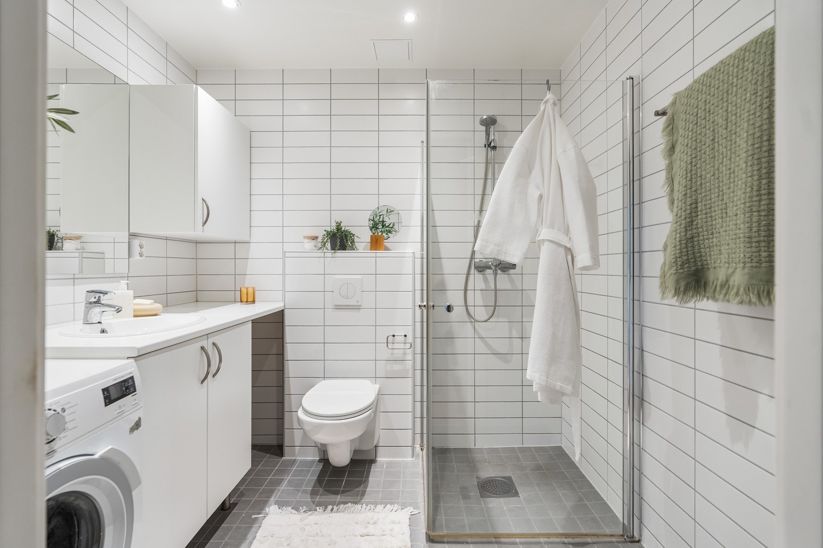 Superpraktisk flislagt bad med varmekabler og opplegg for full vaskesøyle med vaskemaskin og tørketrommel Galleribilde