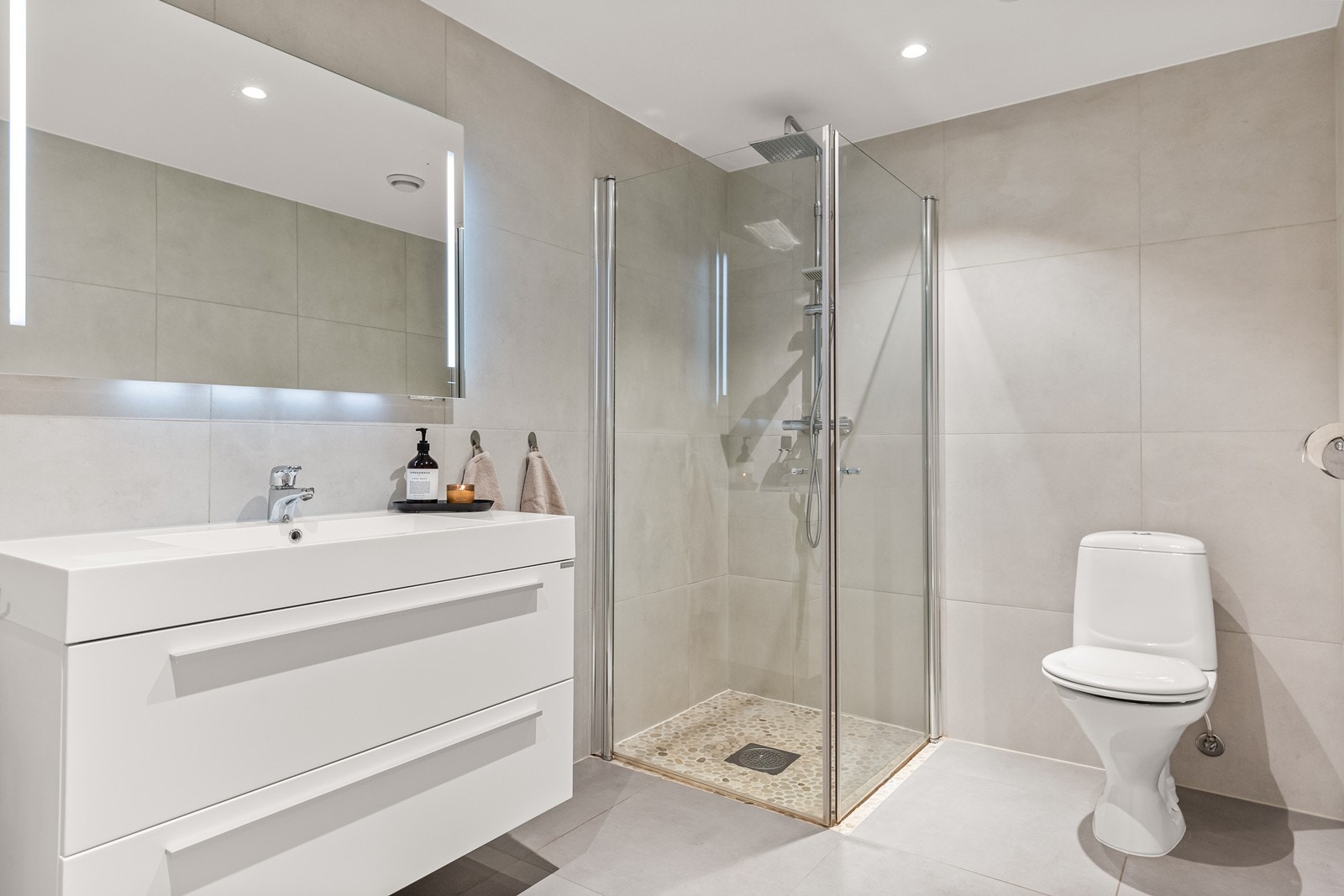 Badet er helfliset og utstyrt med en åpen dusjløsning med dusjvegger. Galleribilde