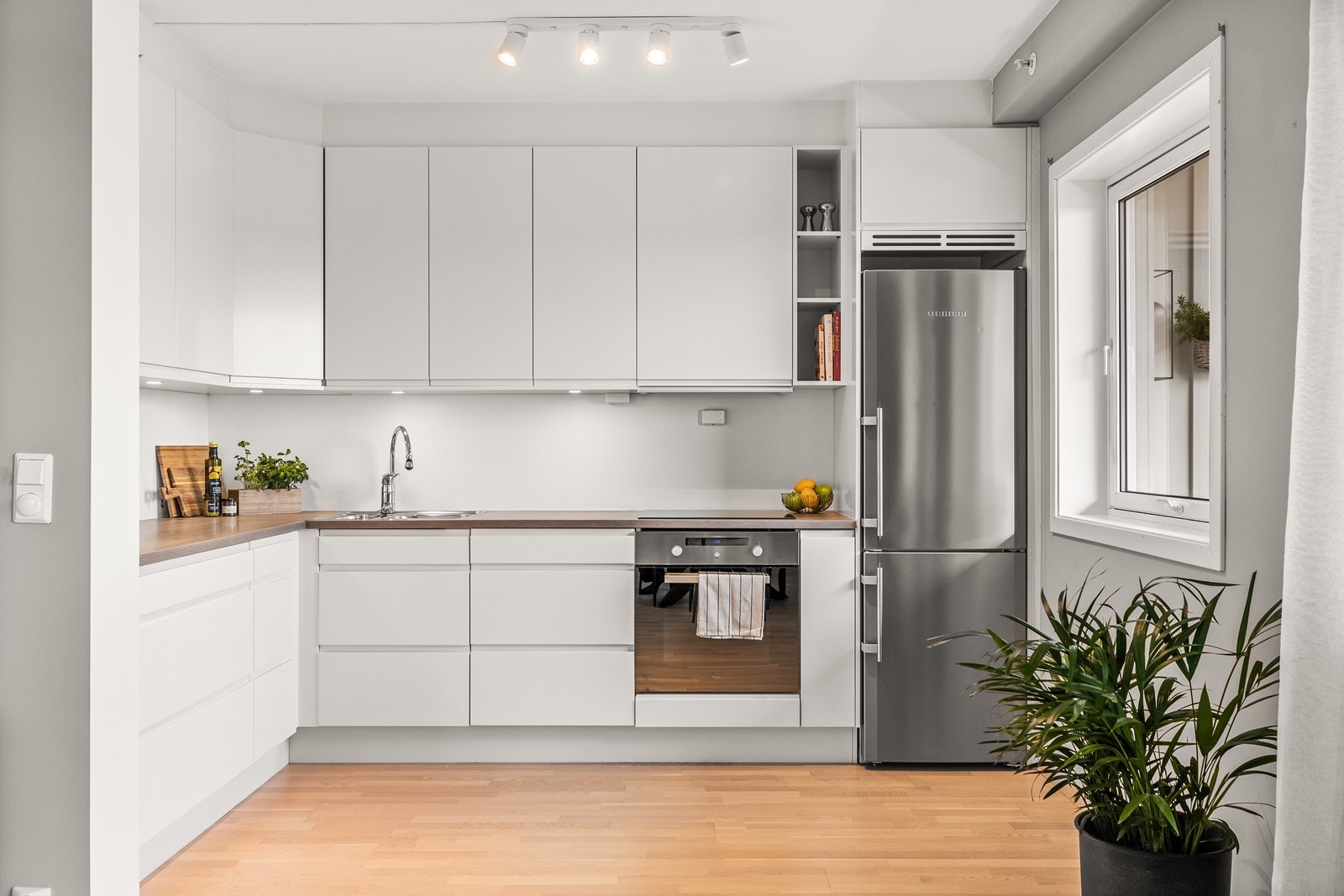 Kjøkkeninnredning fra byggeåret med integrerte hvitevarer og god benkeplass. Galleribilde