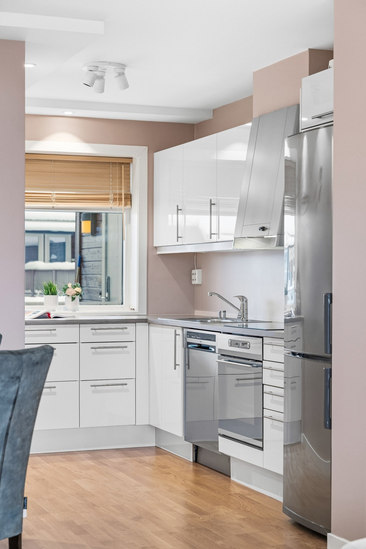 Kjøkkenet har innredning i slett, hvit høyglans med benkeplate i slitesterk laminat. Galleribilde