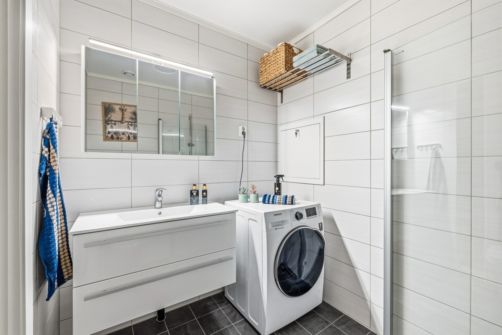 Baderommet er videre utstyrt med hvitt servantskap med skuffer og overliggende servant med ett-greps armatur. Galleribilde