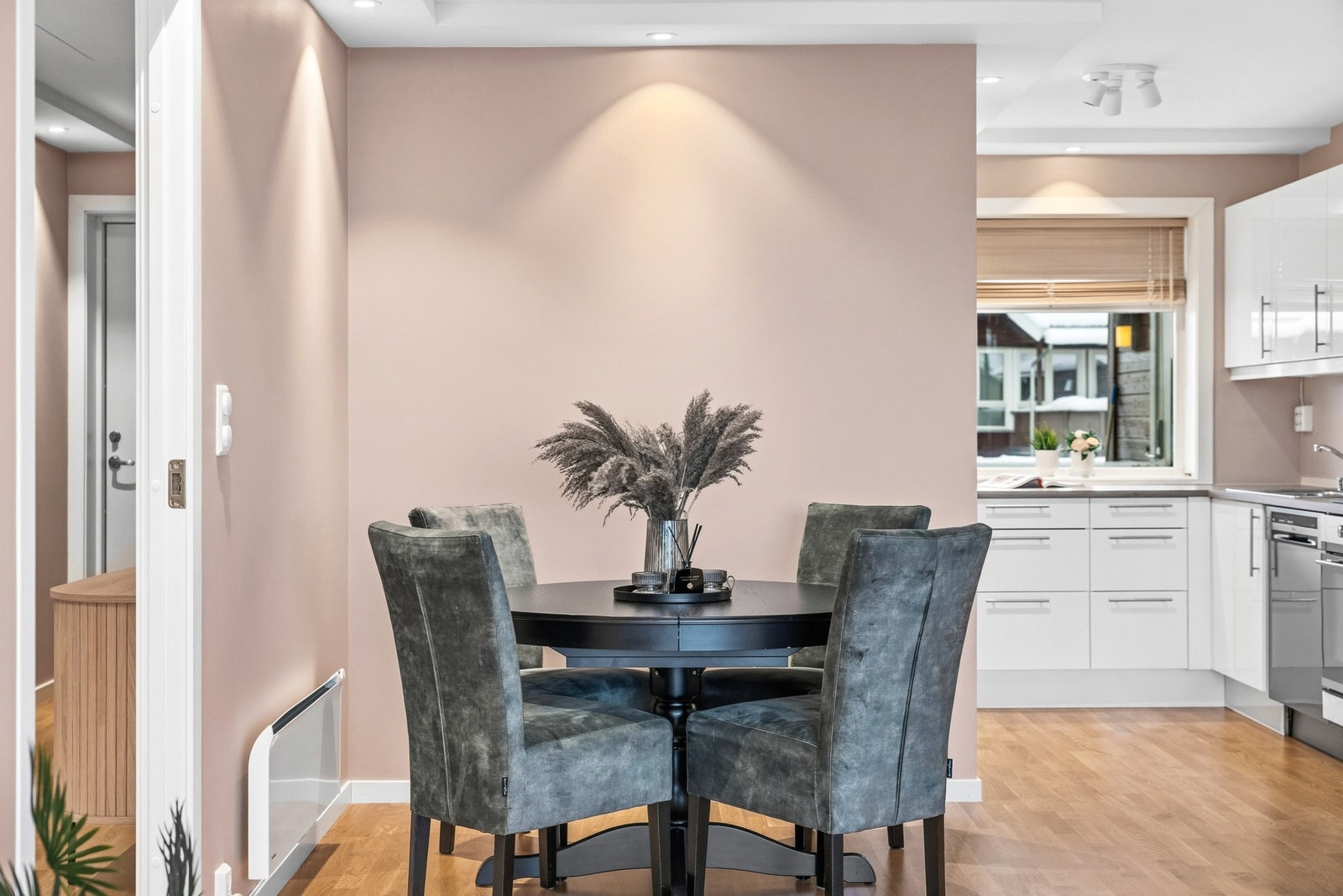 Du kommer fra gangen inn stuen som har åpen løsning til kjøkkenet. Rommet er malt i samme duse rosa som i gangen. Galleribilde