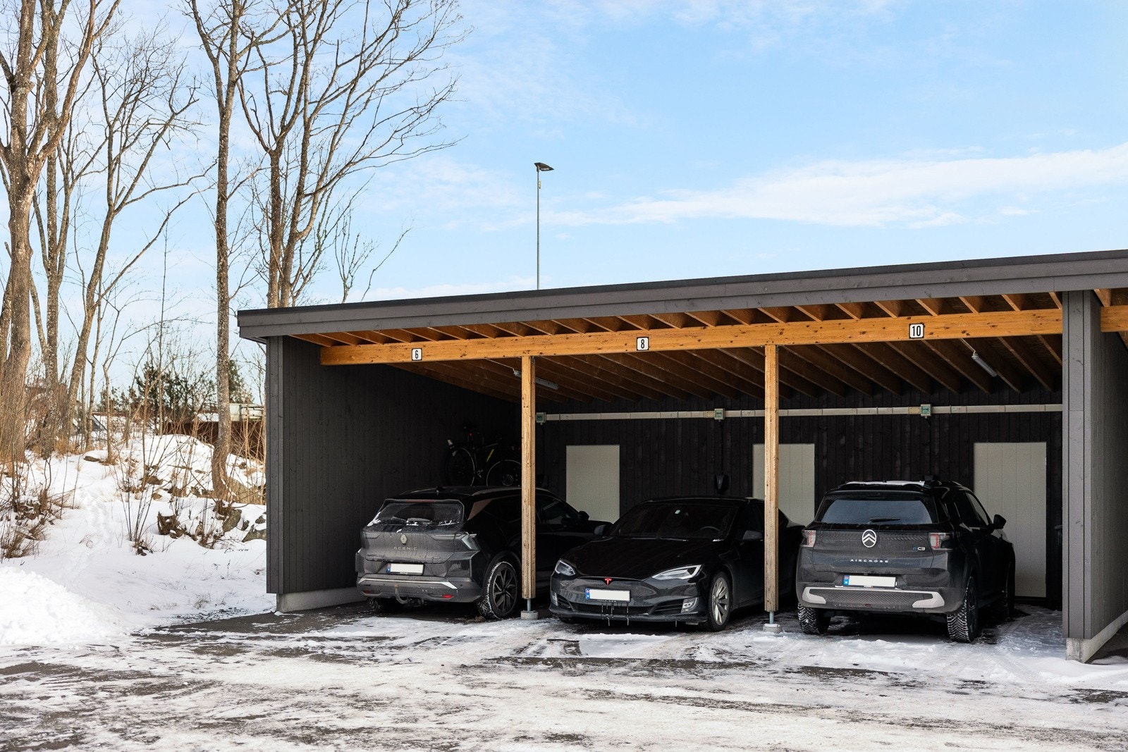 Det følger med egen p-plass i en felles carport med elbil-lader, og det er en hendig bod i bakkant av carporten. Galleribilde