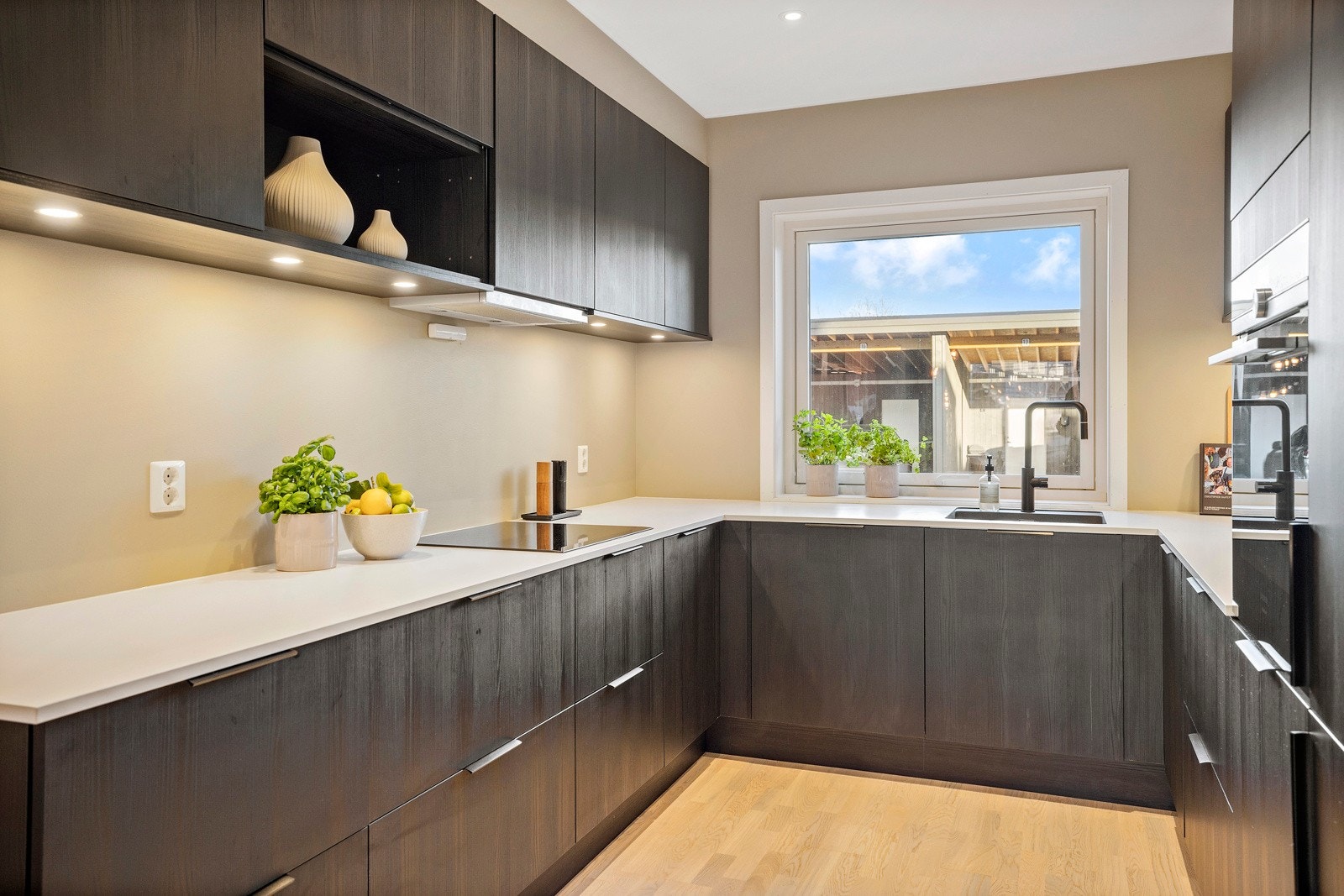 Downlights i deler av himlingen tilfører ekstra lys til arbeidsflatene på kjøkkenet. Galleribilde