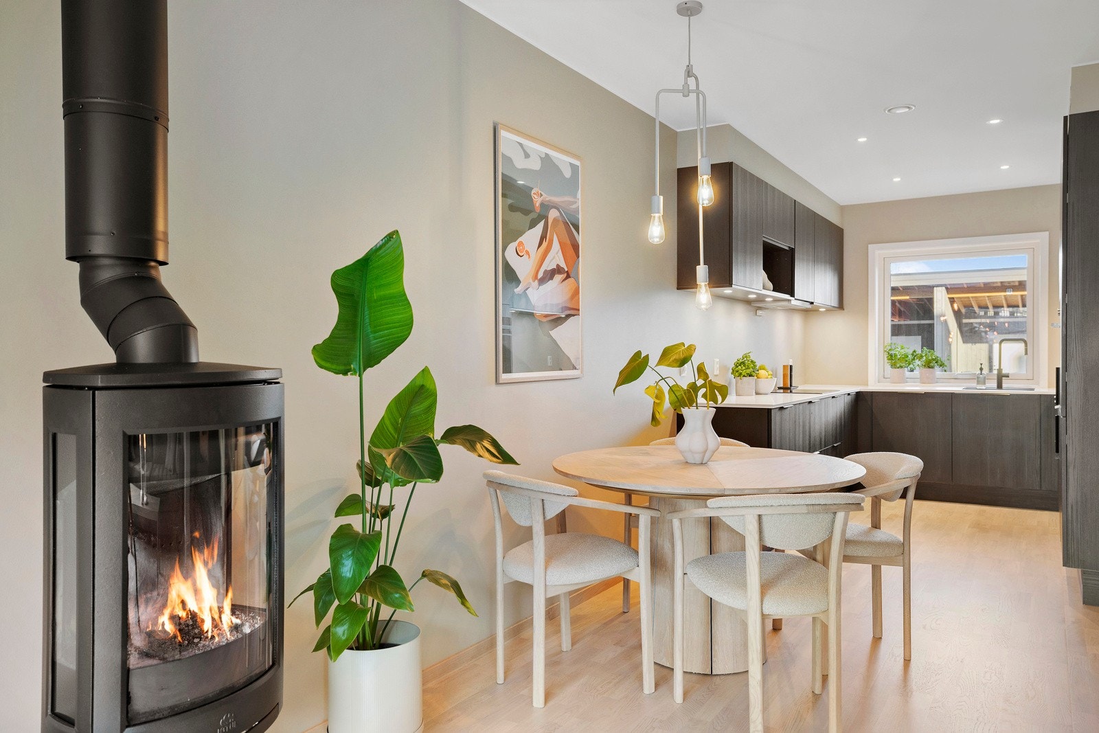 Ildstedet er plassert slik at stemningen nytes fra både spiseplassen og sofakroken. Det ble oppgradert til en lekker Jøtul peis før innflytting i 2022. Galleribilde