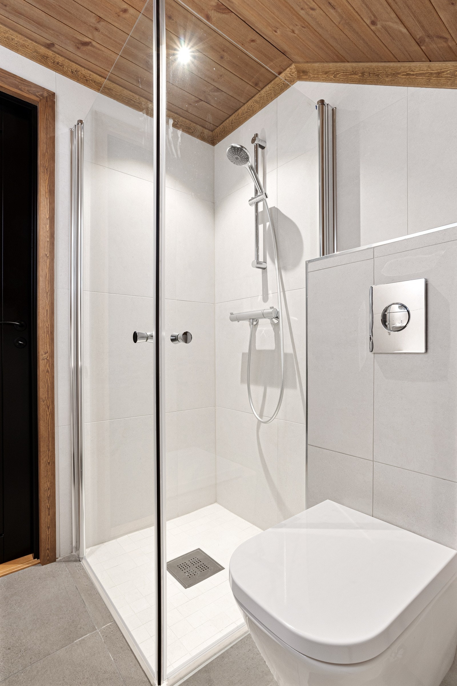 Badet har hel servantplate over skuffeinnredning, speil med integrert lys, dusjnisje og vegghengt toalett Galleribilde