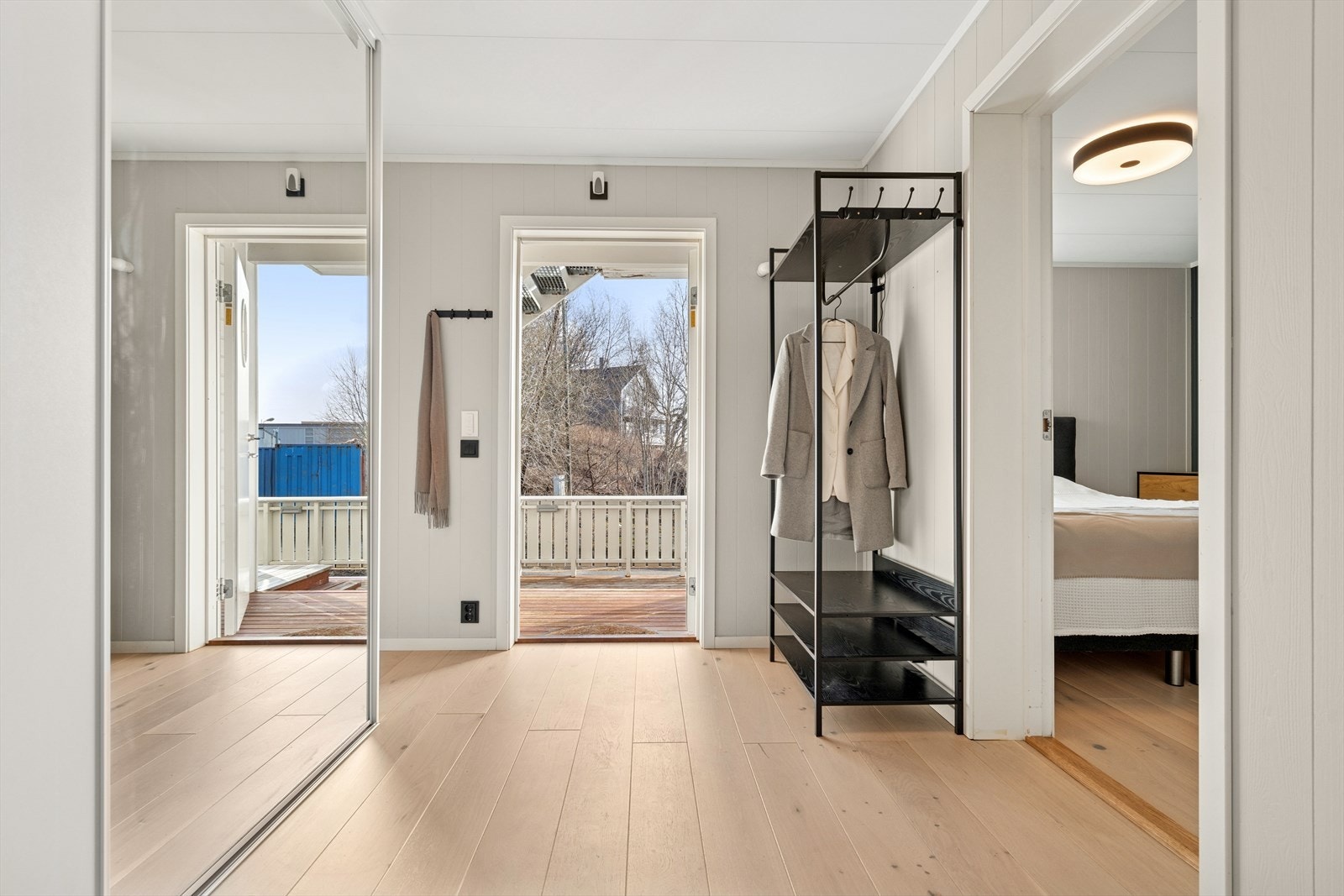 Du ønskes velkommen inn i en romslig og innbydende entrè som er utstyrt med skyvedørsgarderobe Galleribilde