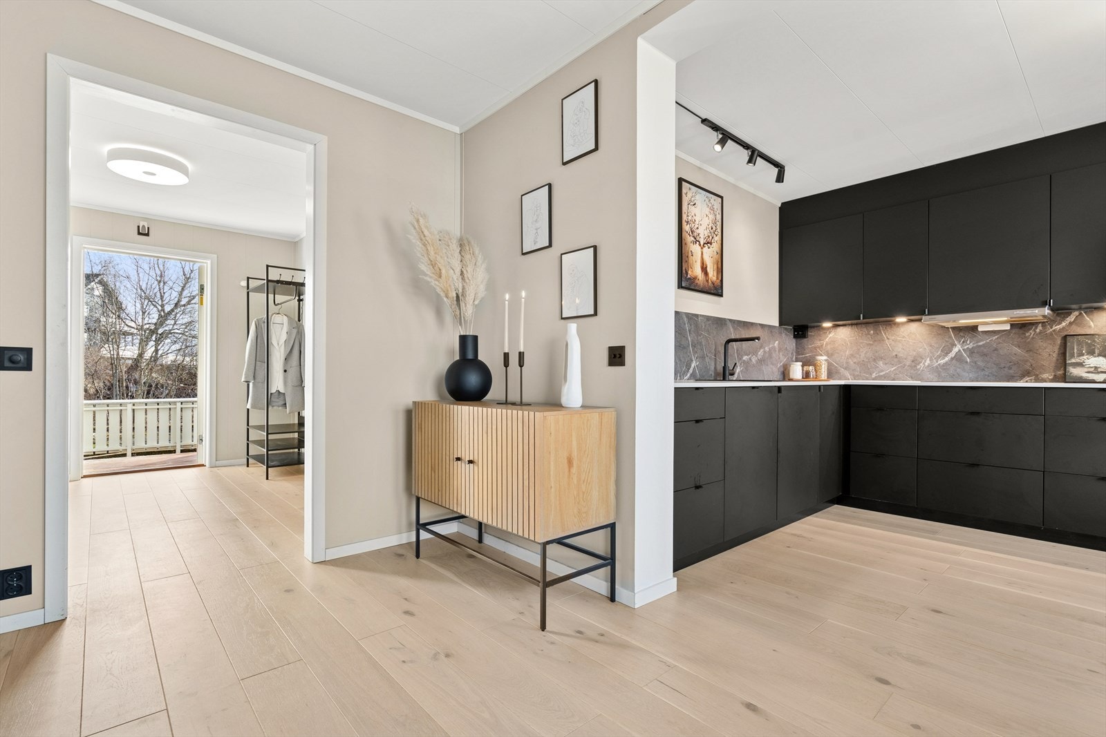 Kjøkkenet ligger i delvis åpen løsning og har en tidsriktig sort kjøkkeninnredning fra Kvik som ble montert i 2022 Galleribilde