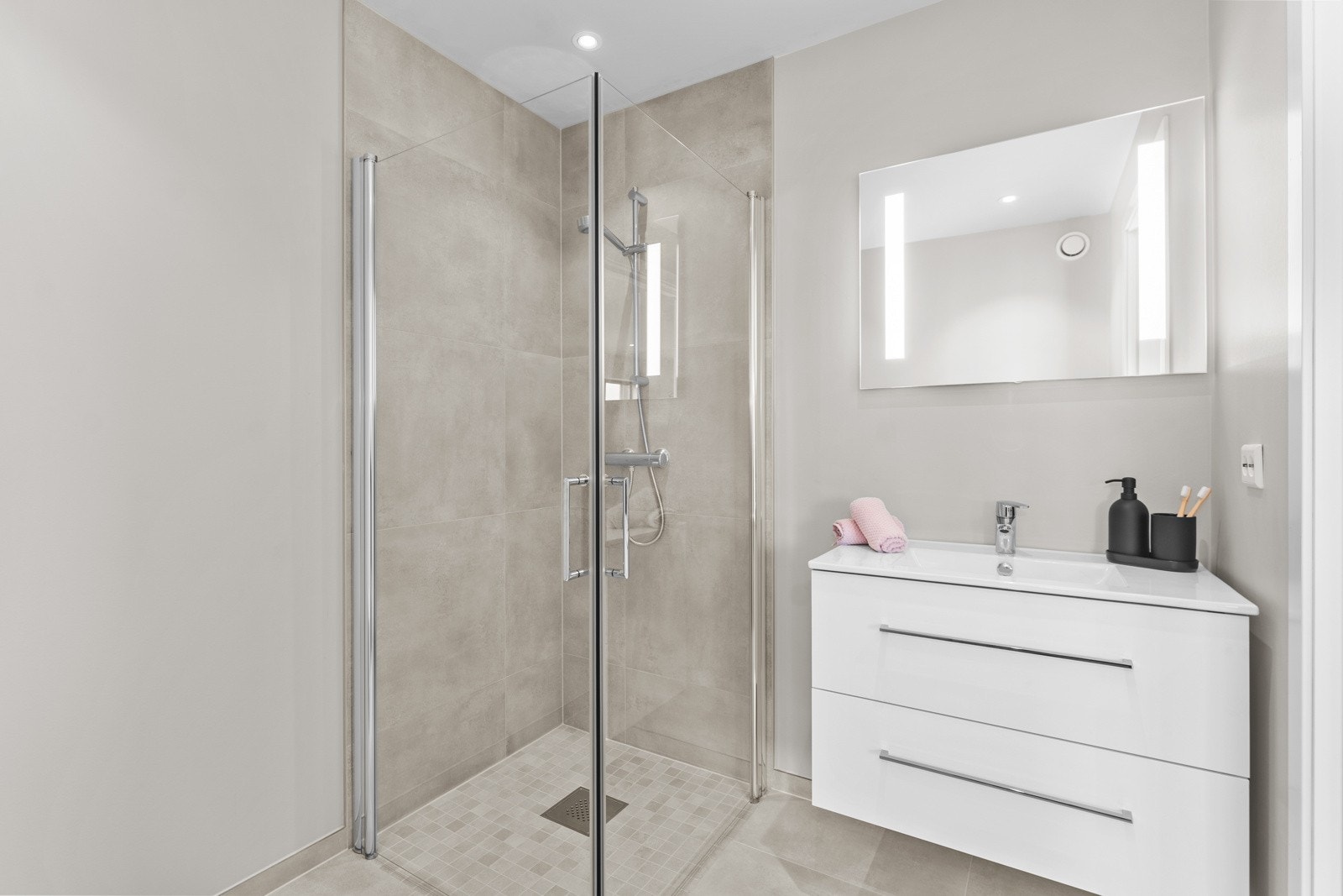 Badet ligger mellom stuen og kjøkkenet. Lekkert innredet med baderomsmøblement og speil med lys. Galleribilde