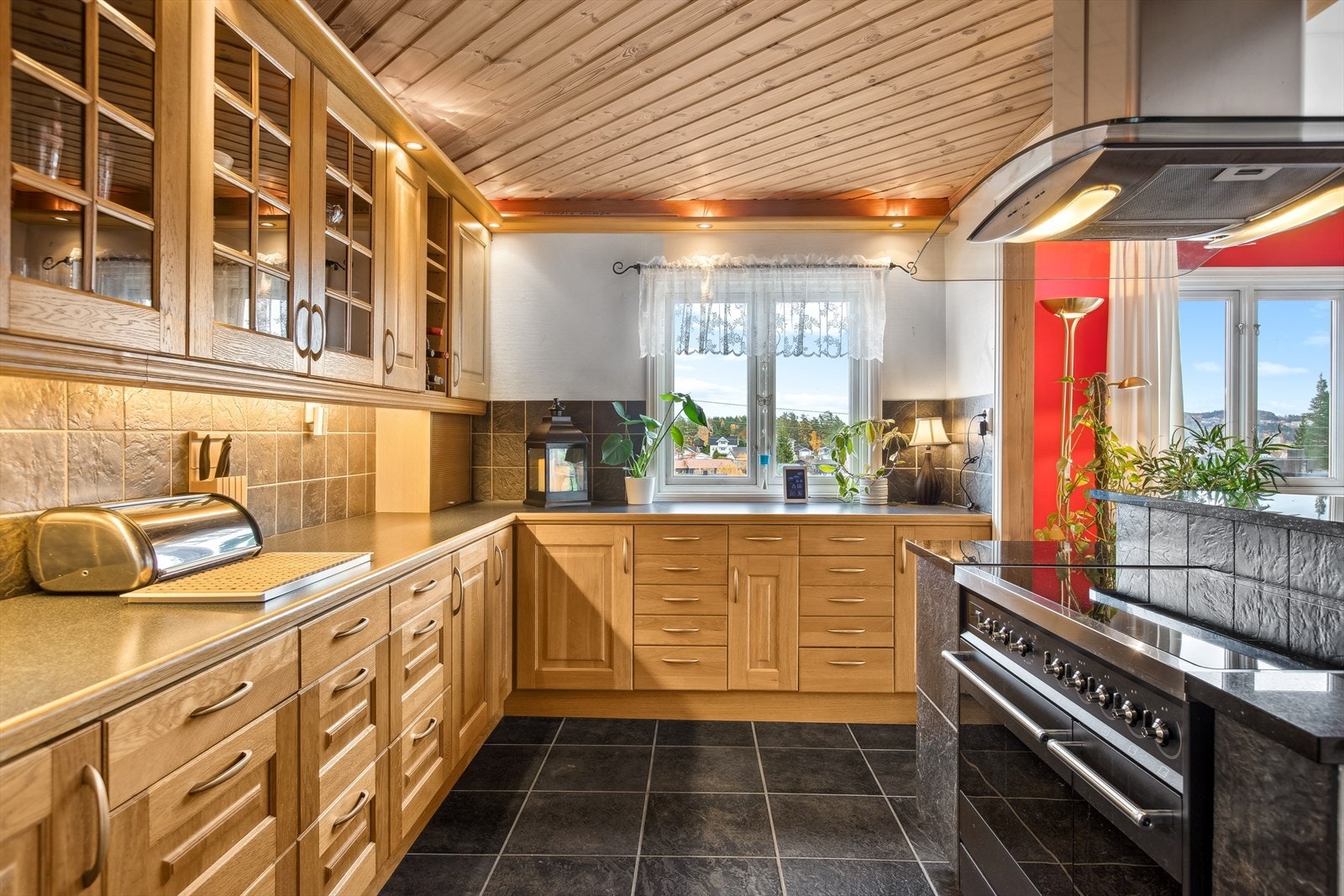 Det er flislagt parti over store deler av benkeplaten og belysning under overskapene. Galleribilde