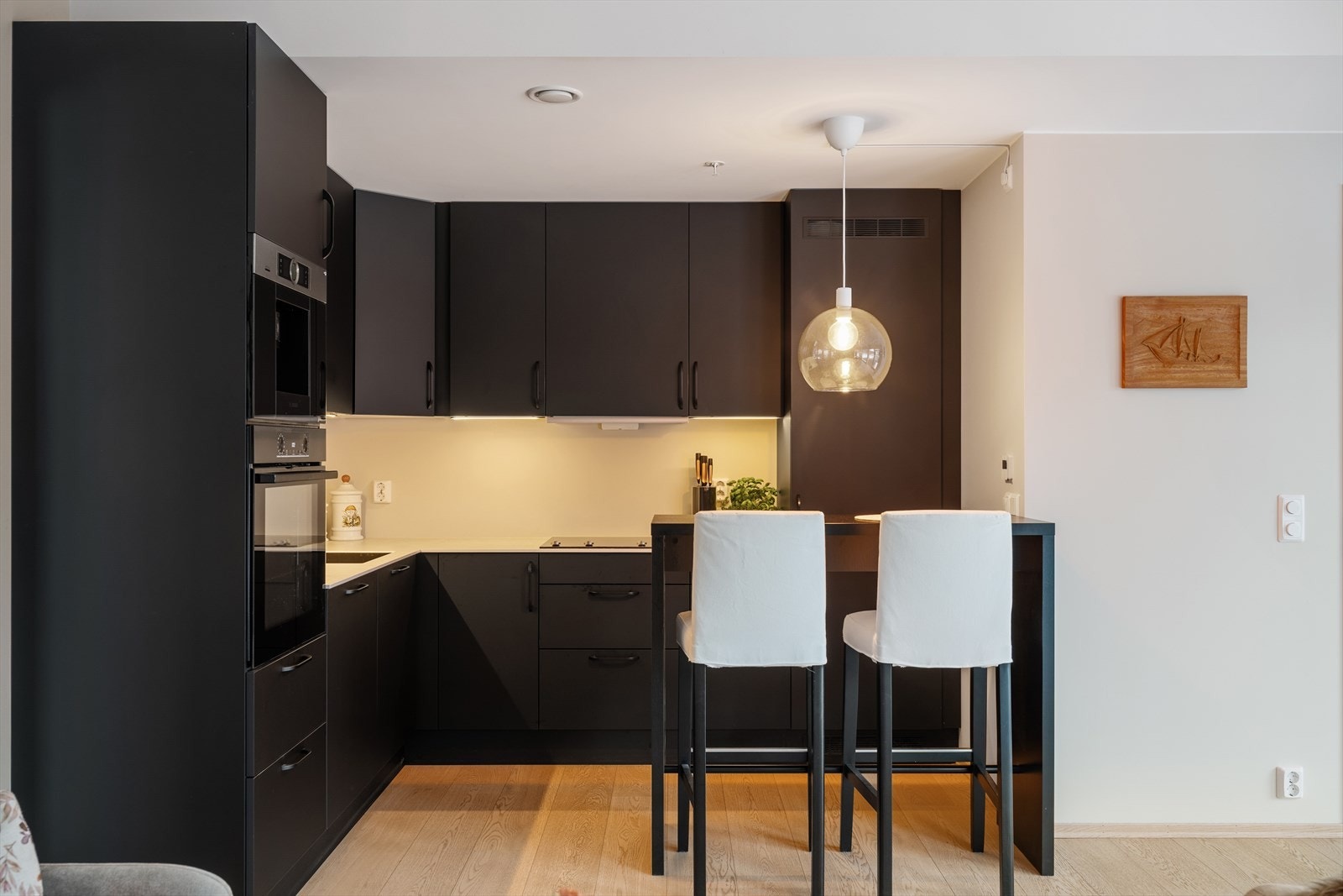 Lekker kjøkkeninnredning med moderne svarte fronter og med Dekton benkeplate (keramisk, sintret steinmateriale). Galleribilde