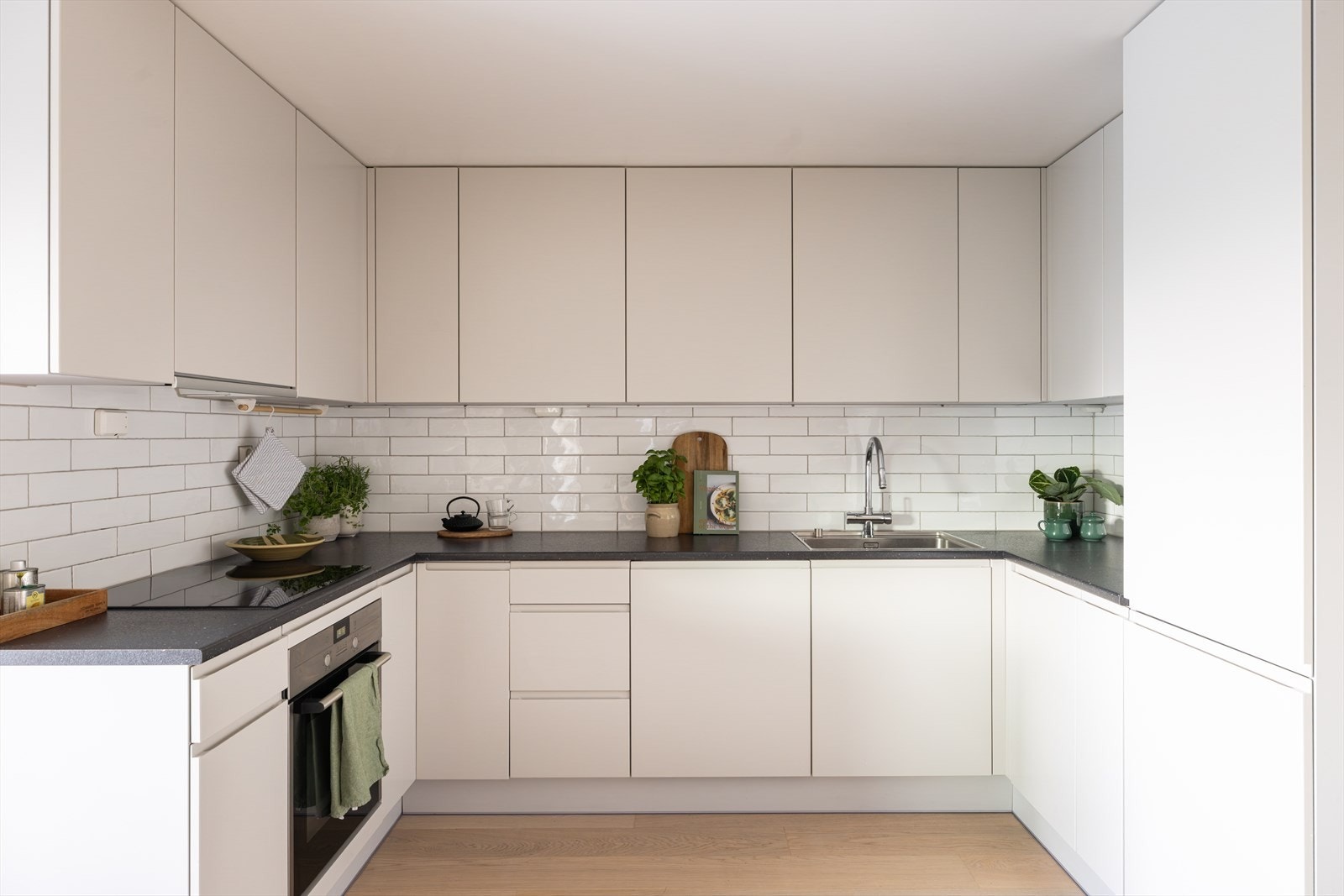 Tidløst og praktisk kjøkken med god skap- og benkeplass. Kjøkkeninnredning fra Arens med laminerte benkeplater, flislagt backsplash og slette skapfronter. Galleribilde