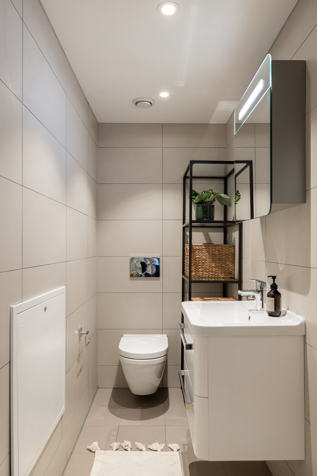 Meget praktisk med ekstra gjestetoalett med toalett og servant. Rommet står i stil til baderommet med delikate fliser og hvit innredning. Galleribilde