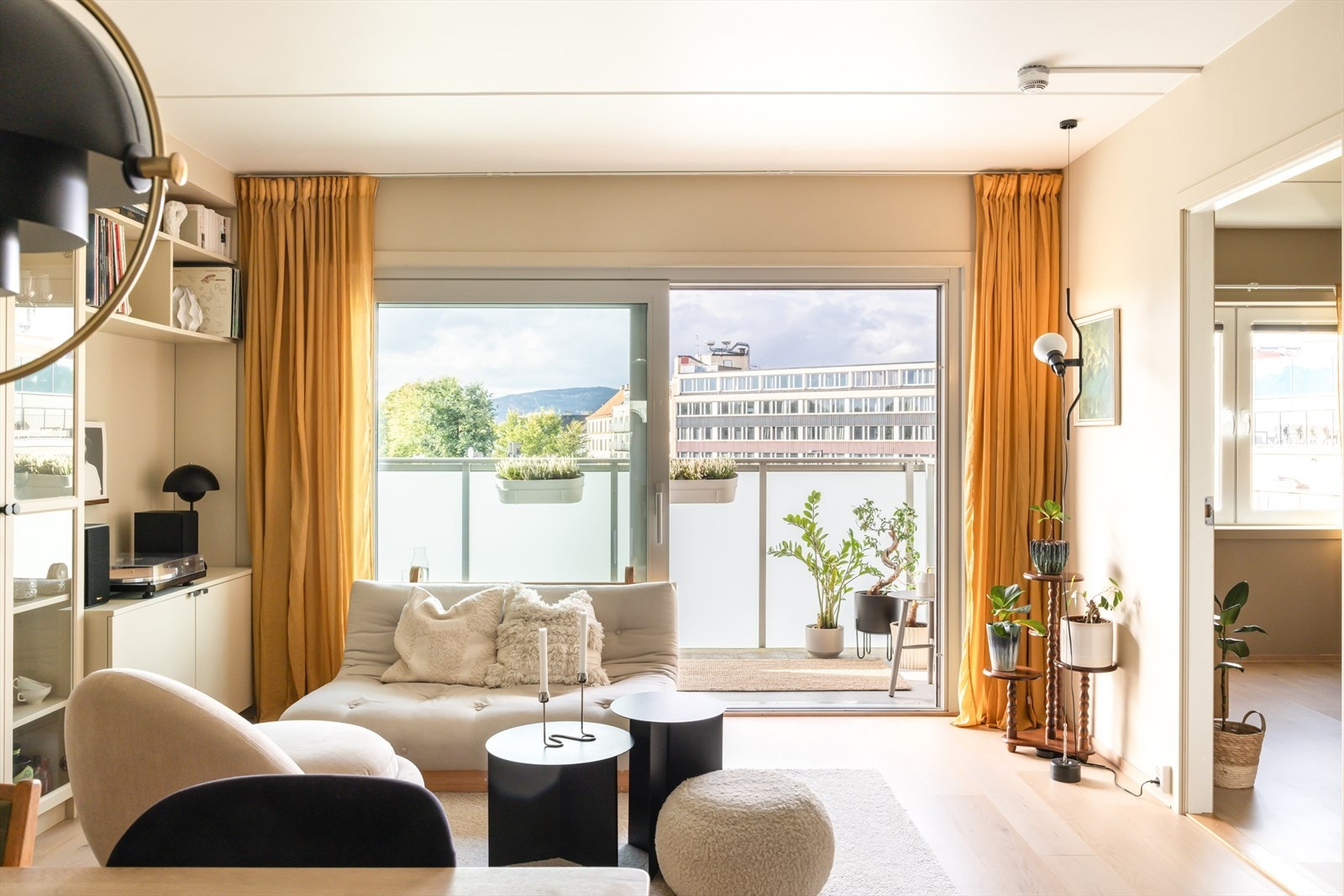 Hele kortveggen i stuen er dekket av store vindusflater, og en stor skyvedør som kan åpnes mot balkong. Dette gjør så den fungerer som en forlengelse av stuen om sommeren. Galleribilde