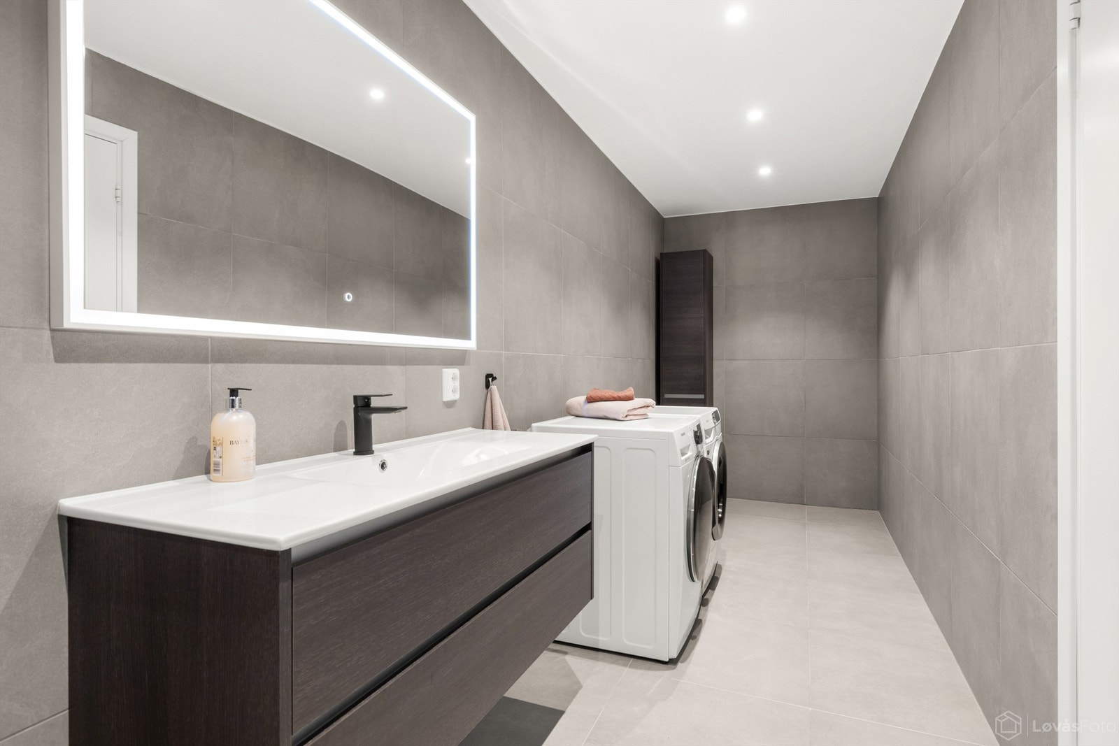 Innredningen har vegghengt servantskap med skuffer og speil med belysning. Galleribilde