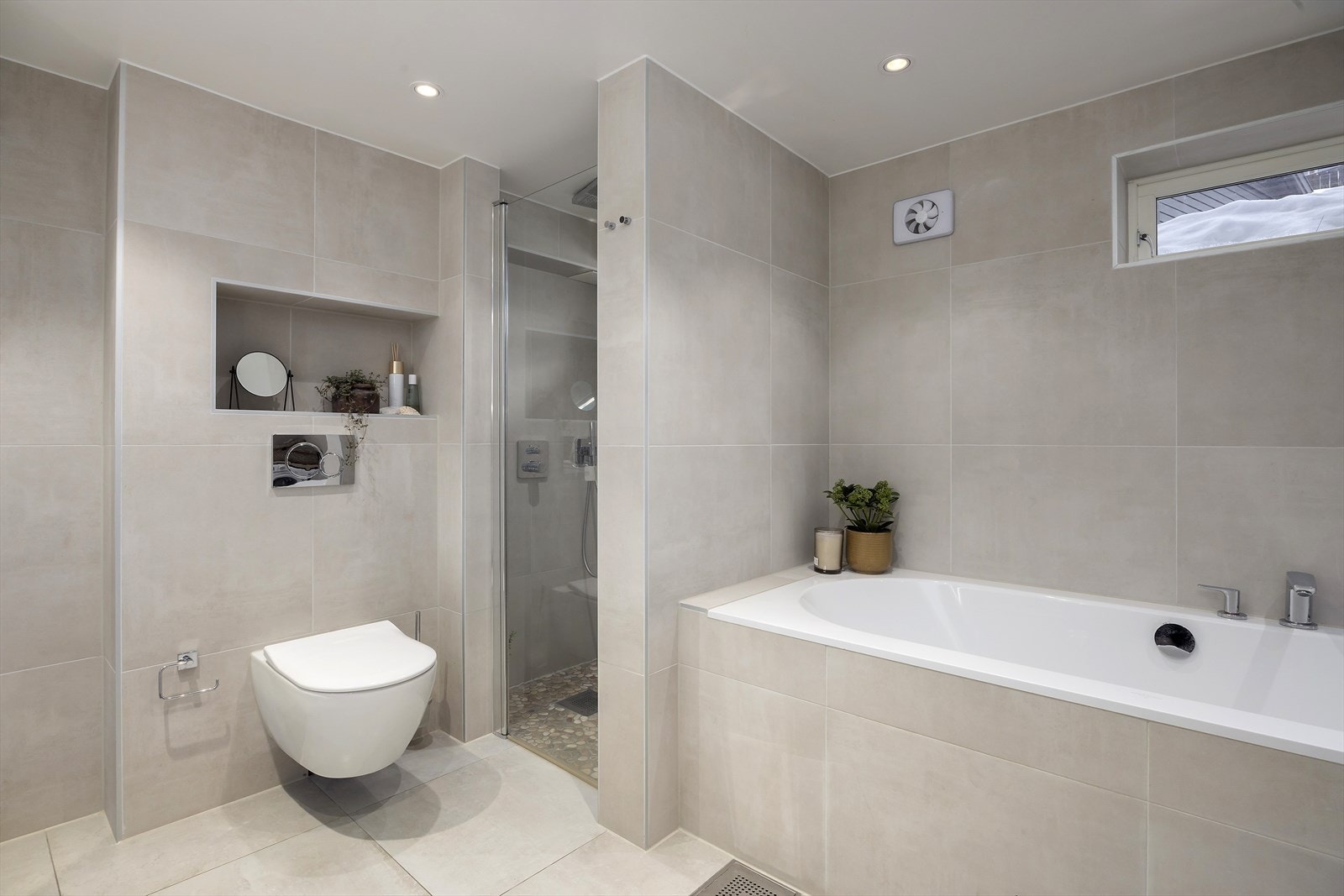 Badet har fliser i lys og moderne farge, varmekabler i gulvet og downlightsbelysning. Elektrisk avtrekk. Galleribilde