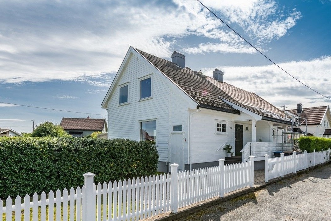 Boligen fra 1957 presenterer seg med en klassisk fasade og et innbydende, hvitt stakittgjerde. Galleribilde