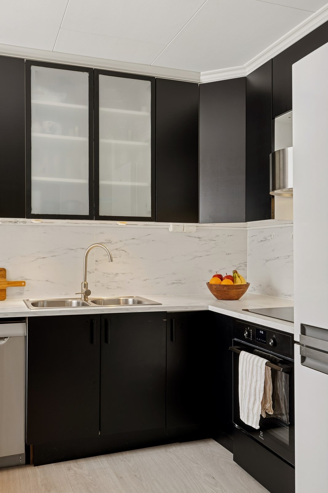 Moderne kjøkken med integrerte hvitevarer, inkludert stekeovn fra 2025, samt frittstående kjøl/frys. Galleribilde