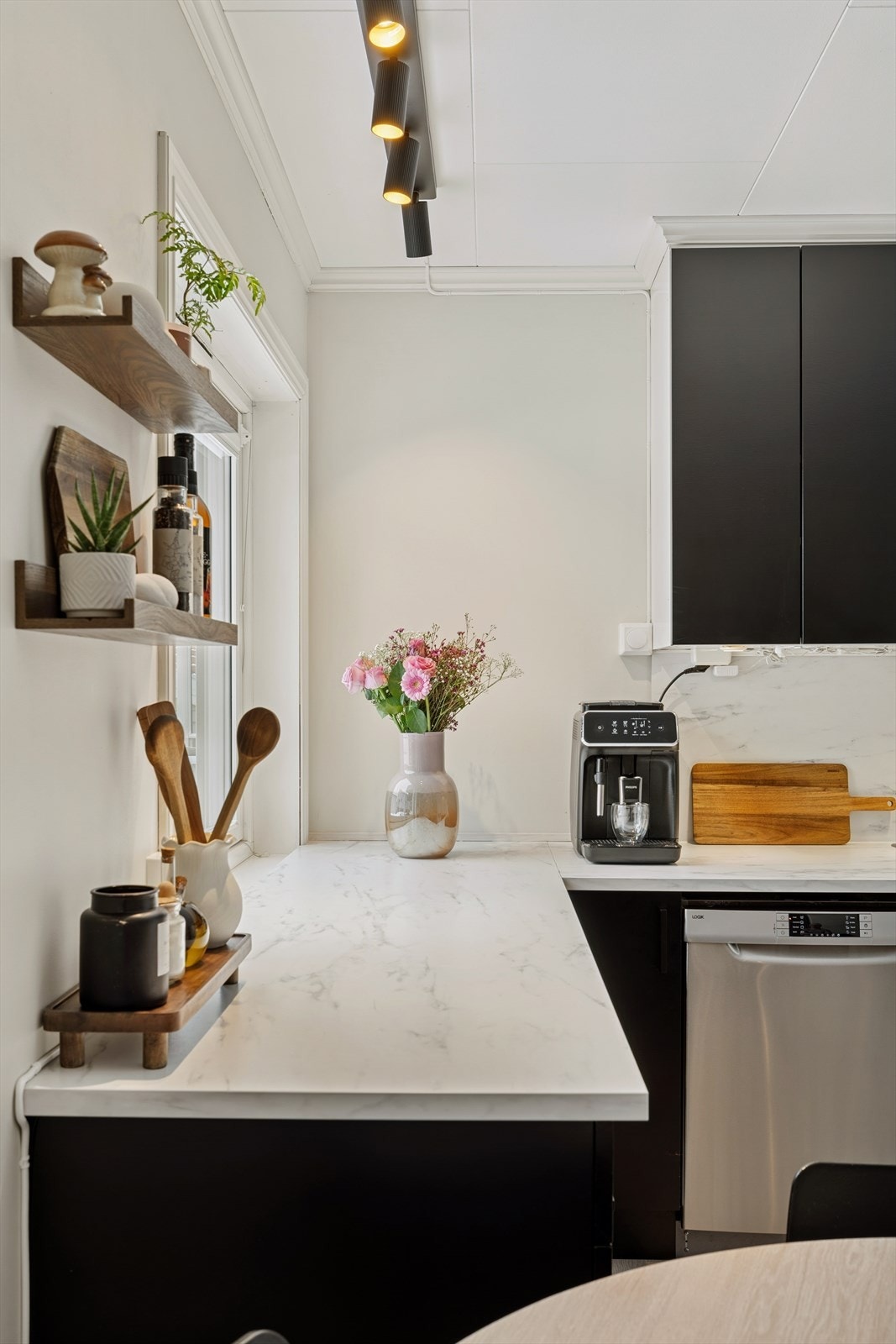 Boligens kjøkken er stilrent og tidløst med svart innredning, laminat benkeplate og rikelig skapplass. Galleribilde