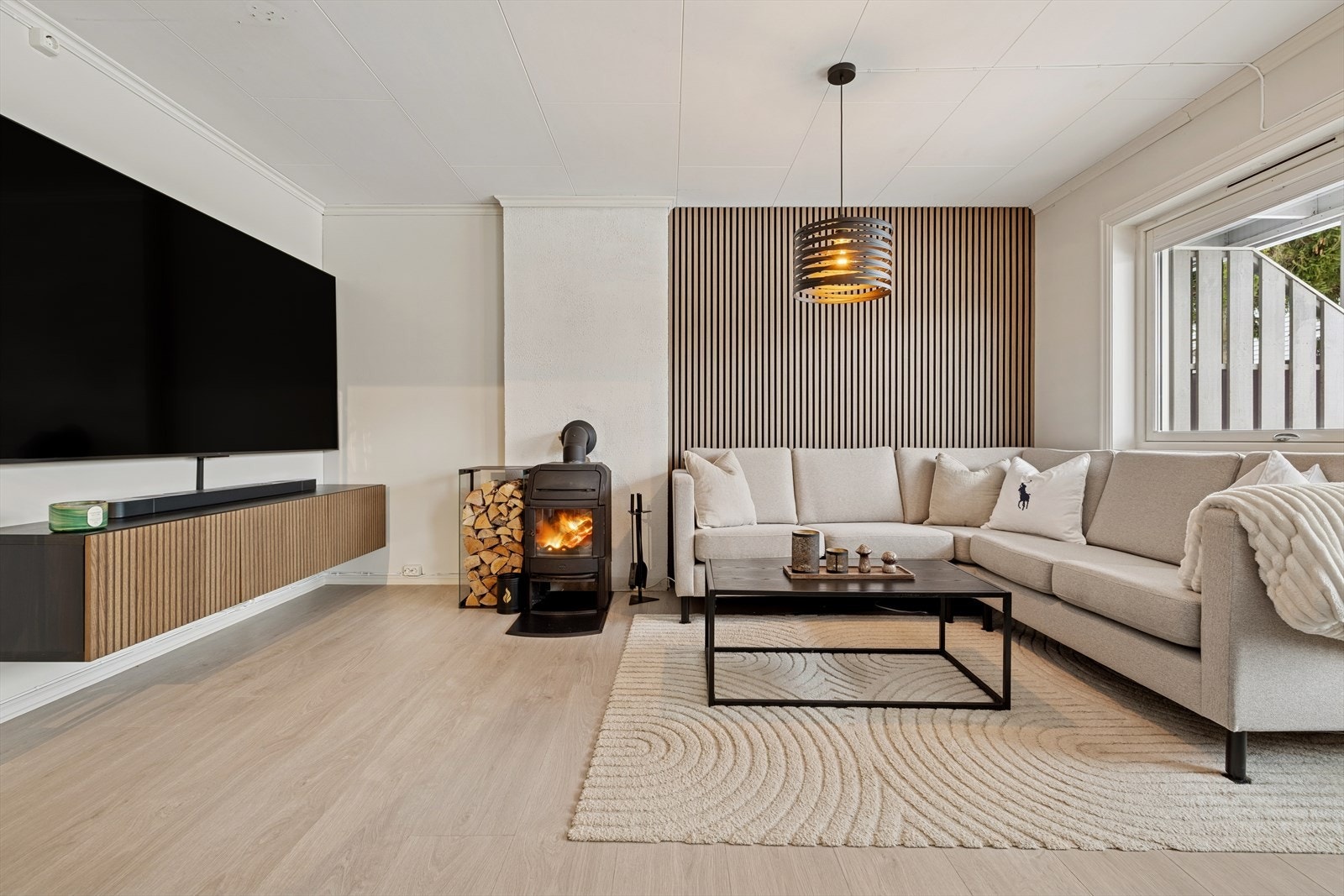 Stilren spilevegg og gjennomførte overflater som rammer inn en god oppholdsflate. Galleribilde