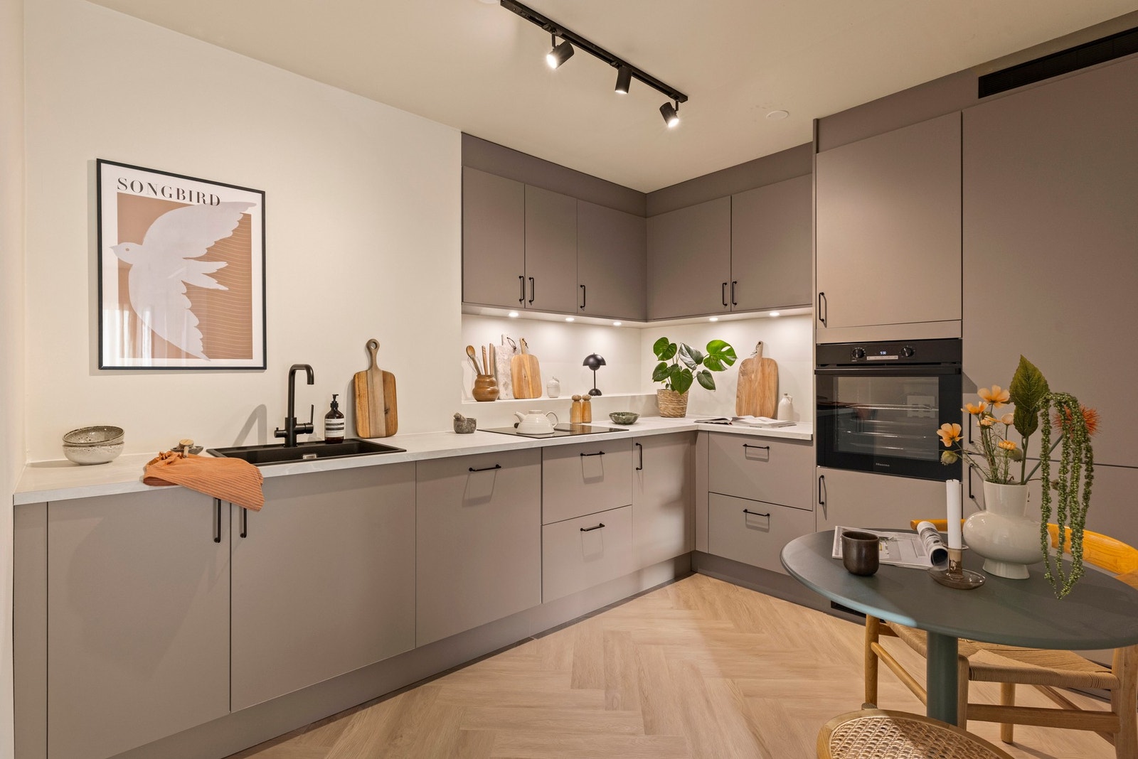 Kjøkkenet fremstår moderne og tidløst med stilren innredning, rikelig med benkeplass og gode oppbevaringsløsninger Galleribilde