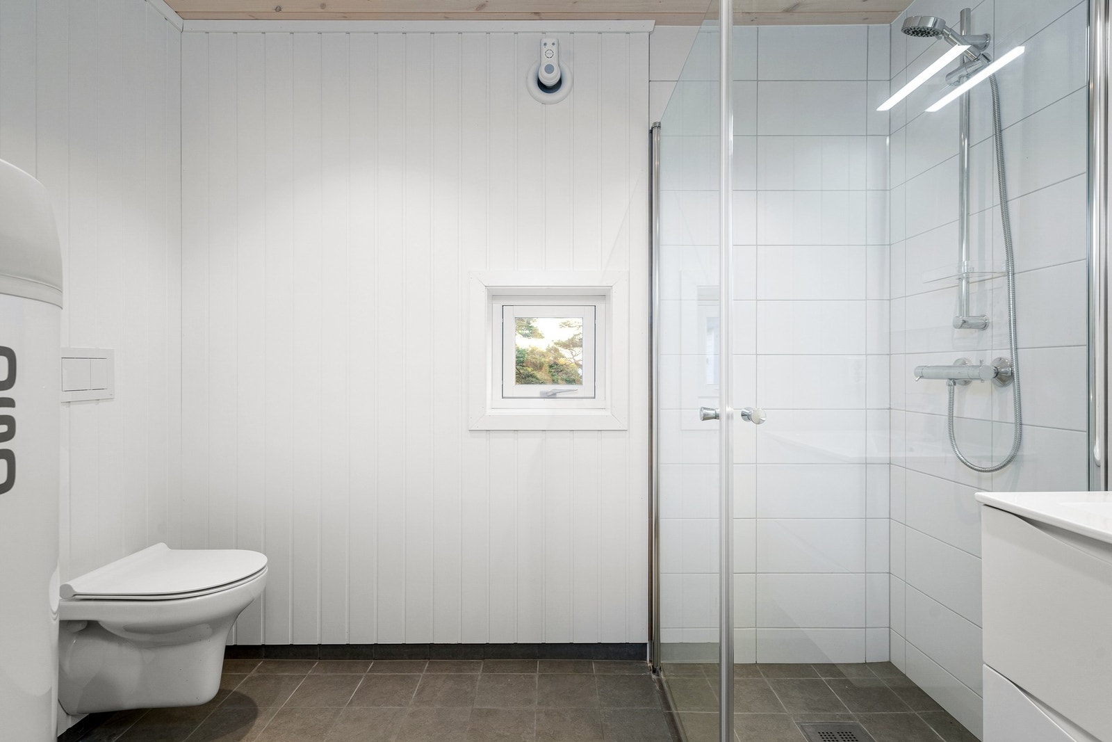 Badet er klassisk gjennomført med fliser på gulv og i dusjsonen Galleribilde