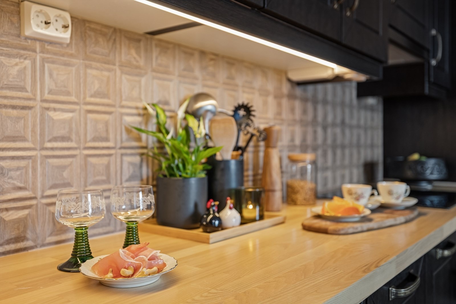 Belysning under overskap gir god arbeidsbelysning på kjøkkenet. Det er lagt nye fliser over kjøkkenbenken. Galleribilde