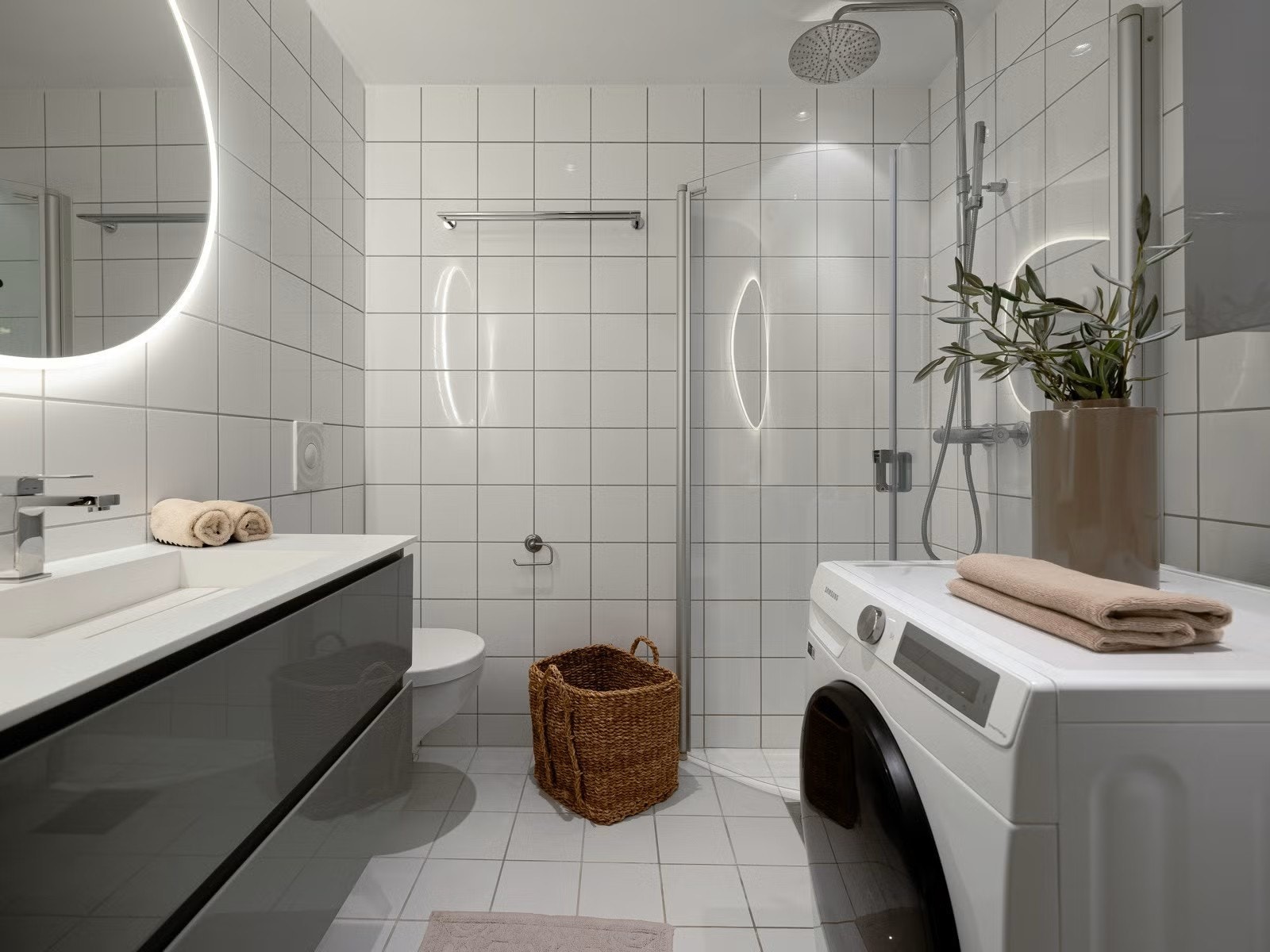 Delikat flislagt bad med kombi vaskemaskin og tørketrommel Galleribilde