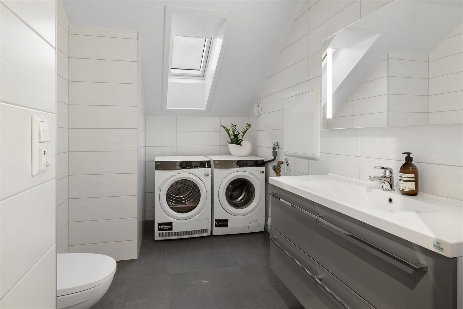 Vaskerommet i 2. etasjen er innredet med servant med underskap som gir praktisk oppbevaringsplass, samt speil med integrert belysning. Galleribilde