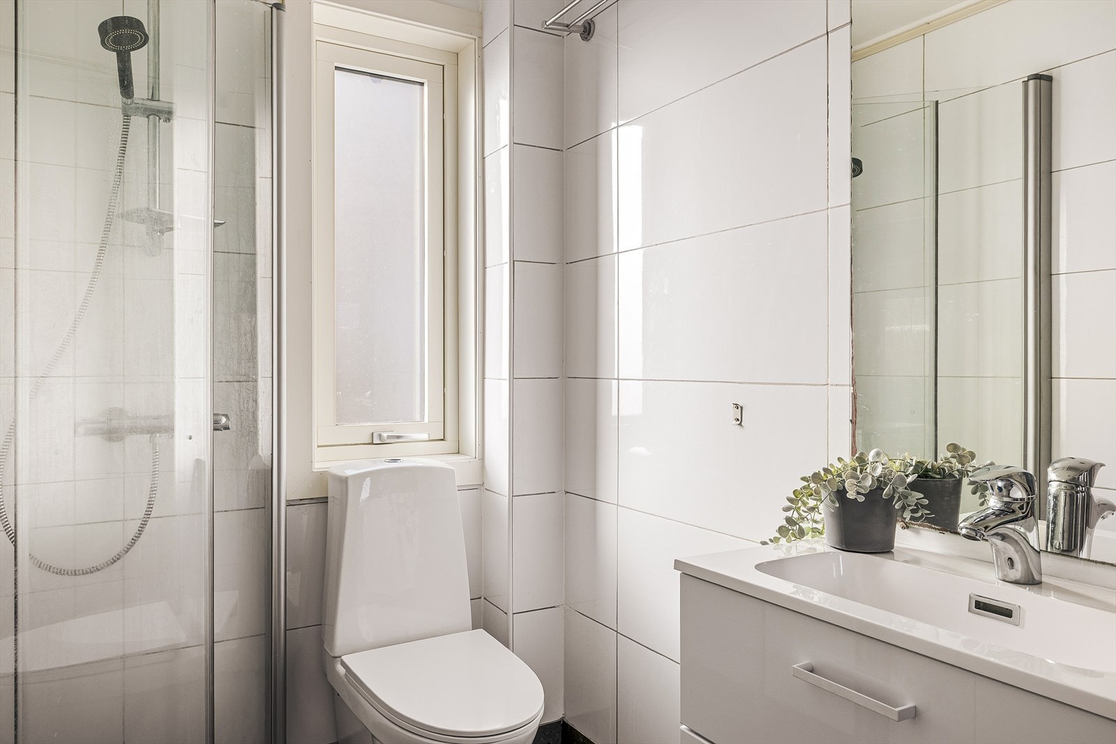 Badet inneholder servant med møblement/speil, belysning, toalett, dusjgarnityr, dusjhjørne og opplegg for vaskemaskin. Galleribilde