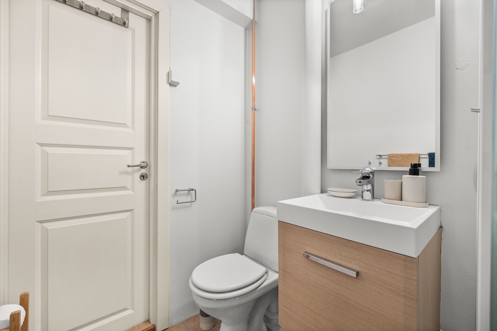 Badet er innredet med toalett, servant nedfelt i innredning og dusjkabinett. Galleribilde