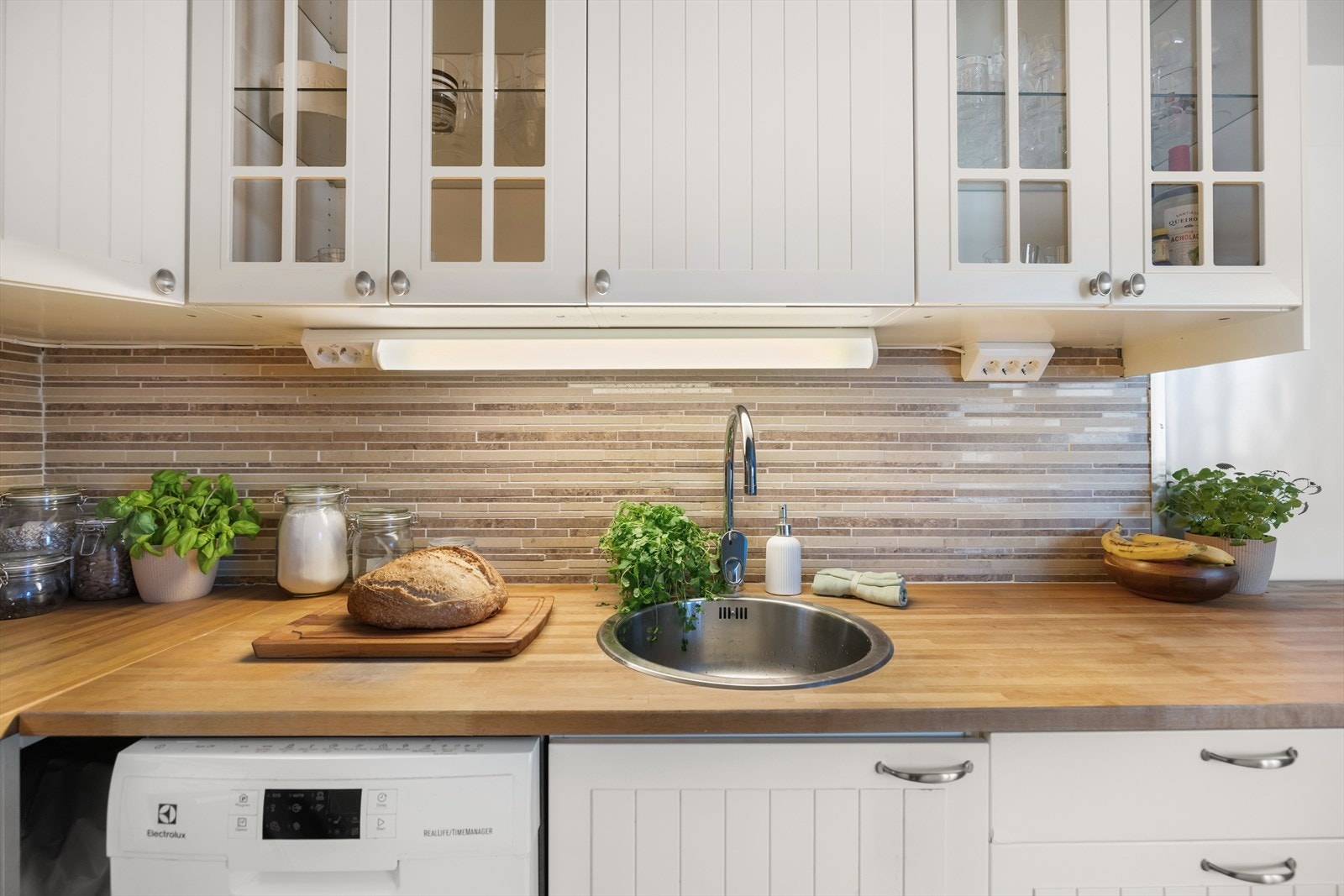 Det er opplegg for oppvaskmaskin og kullfilterventilator over kokeplass. Varmtvannstank på ca. 120 liter er integrert i kjøkkeninnredningen. Galleribilde