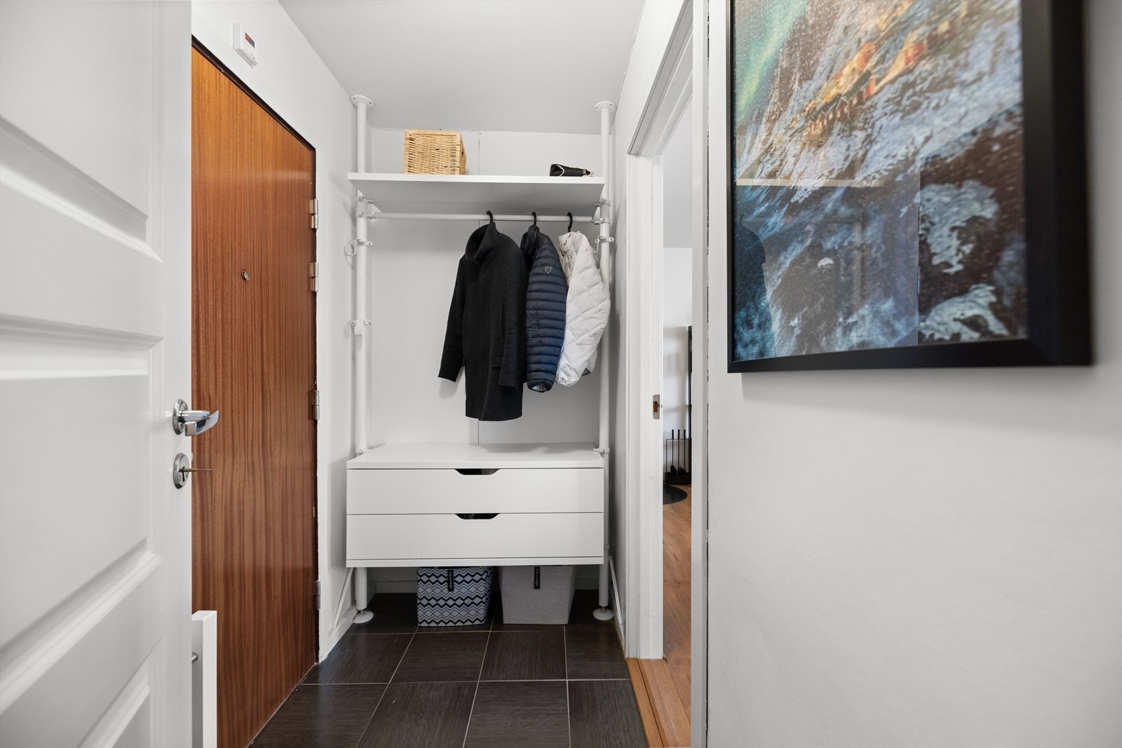 Entréen er praktisk utformet med flislagt gulv som er slitesterkt og lett å holde rent. Her er det gode oppbevaringsmuligheter med garderobeløsning bestående av skuffer, hyller og oppheng for yttertøy. Galleribilde