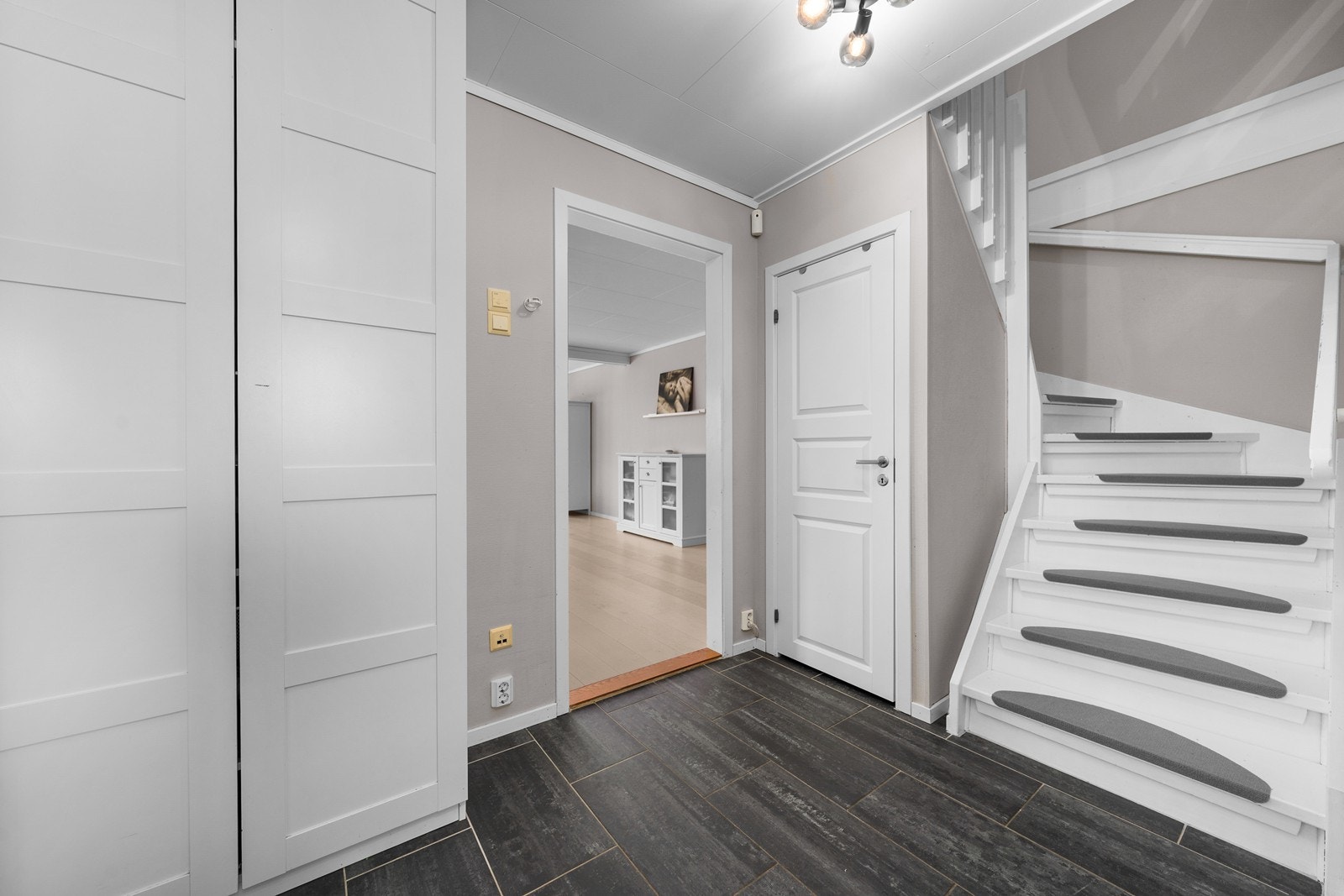 Malt tretrapp med tette opptrinn forbinder første og andre etasje. Galleribilde