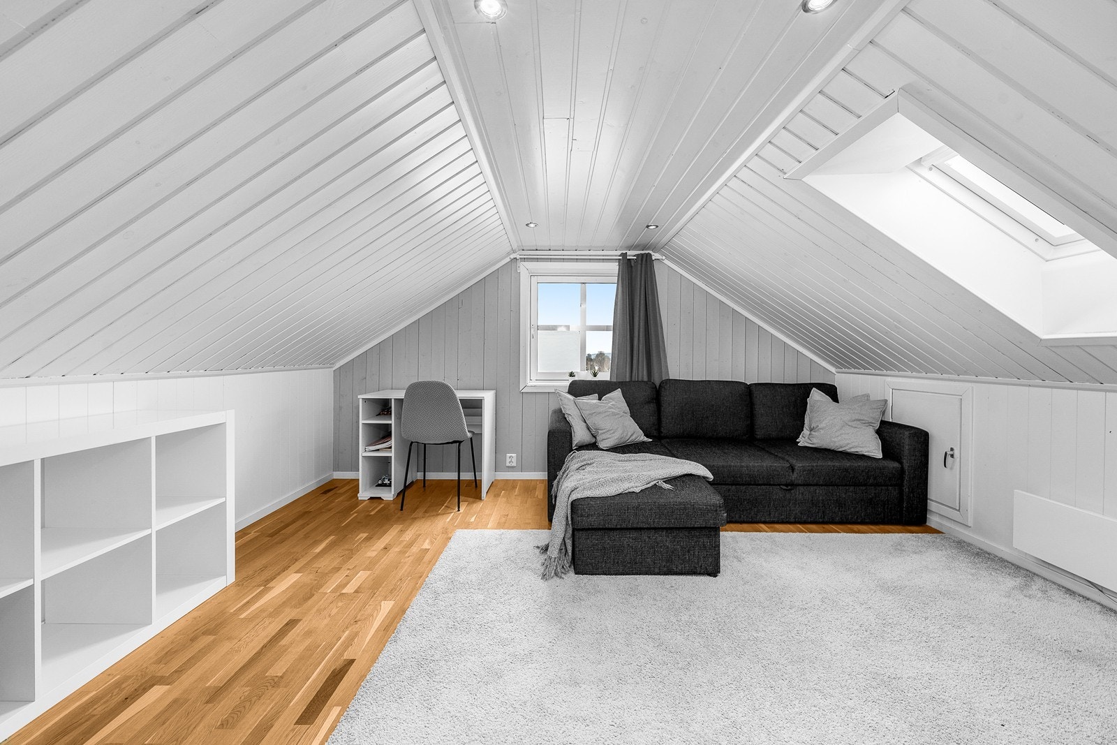 Innredet loftstue med malt panel i taket og Velux takvindu som gir godt lys. Galleribilde