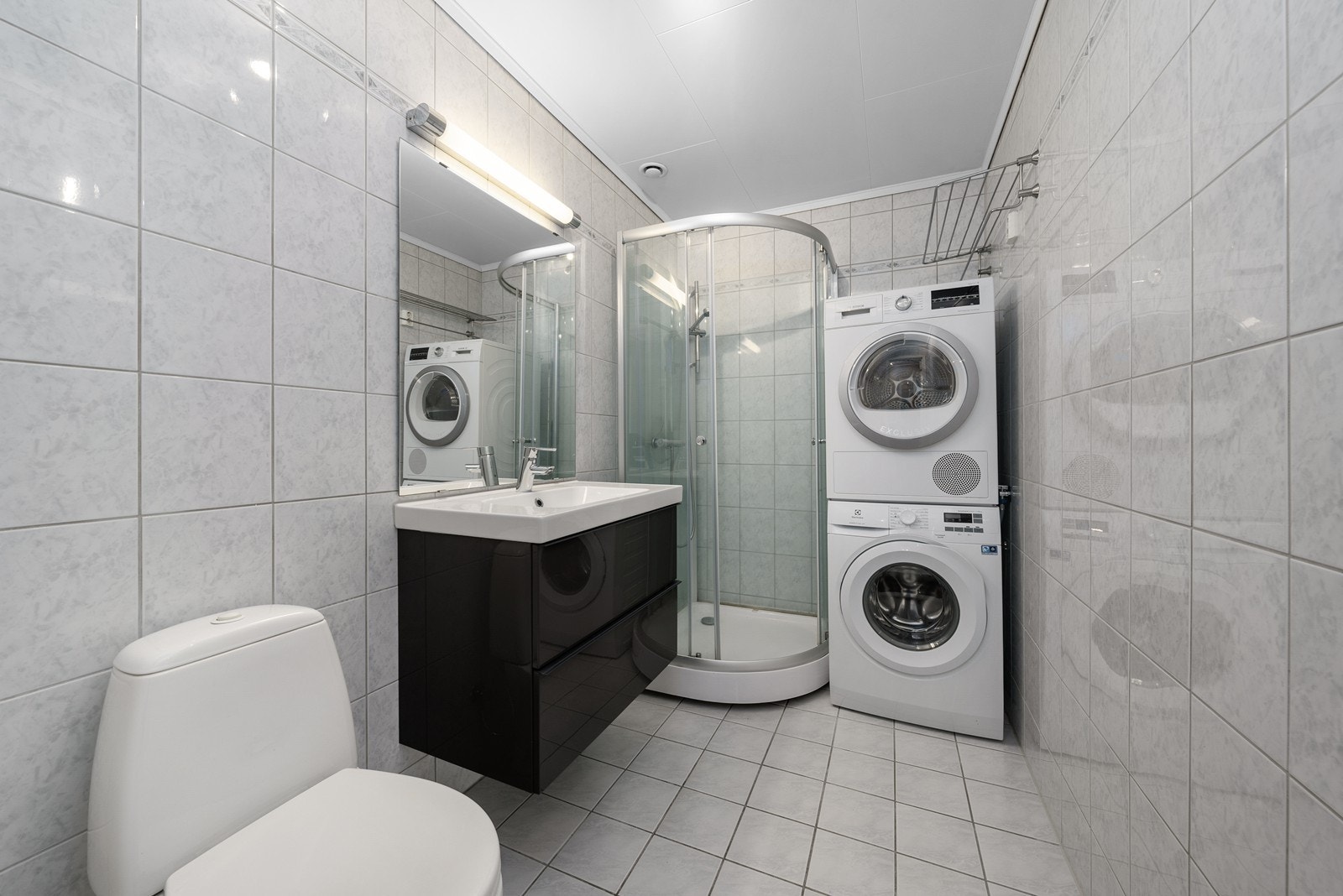 Badet i første etasje har dusjkabinett, servantinnredning og opplegg for vaskemaskin. Galleribilde