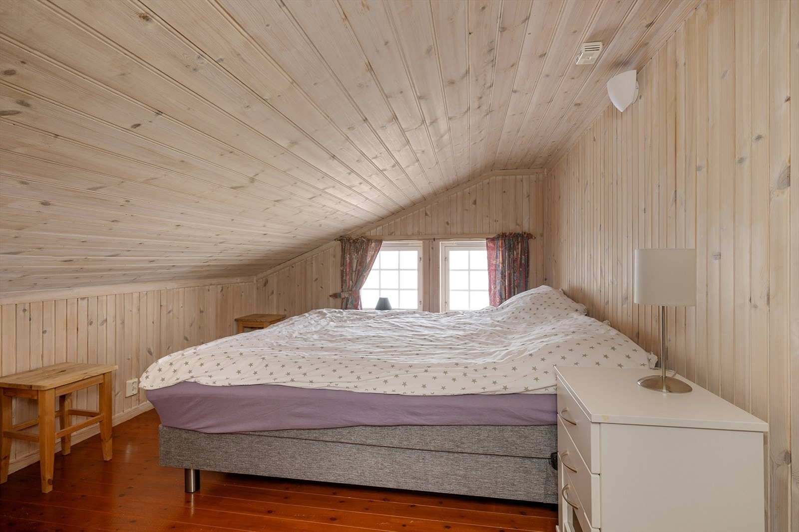 Rom på hemsen innredet med dobbeltseng og oppbevaringsmøbler. Galleribilde