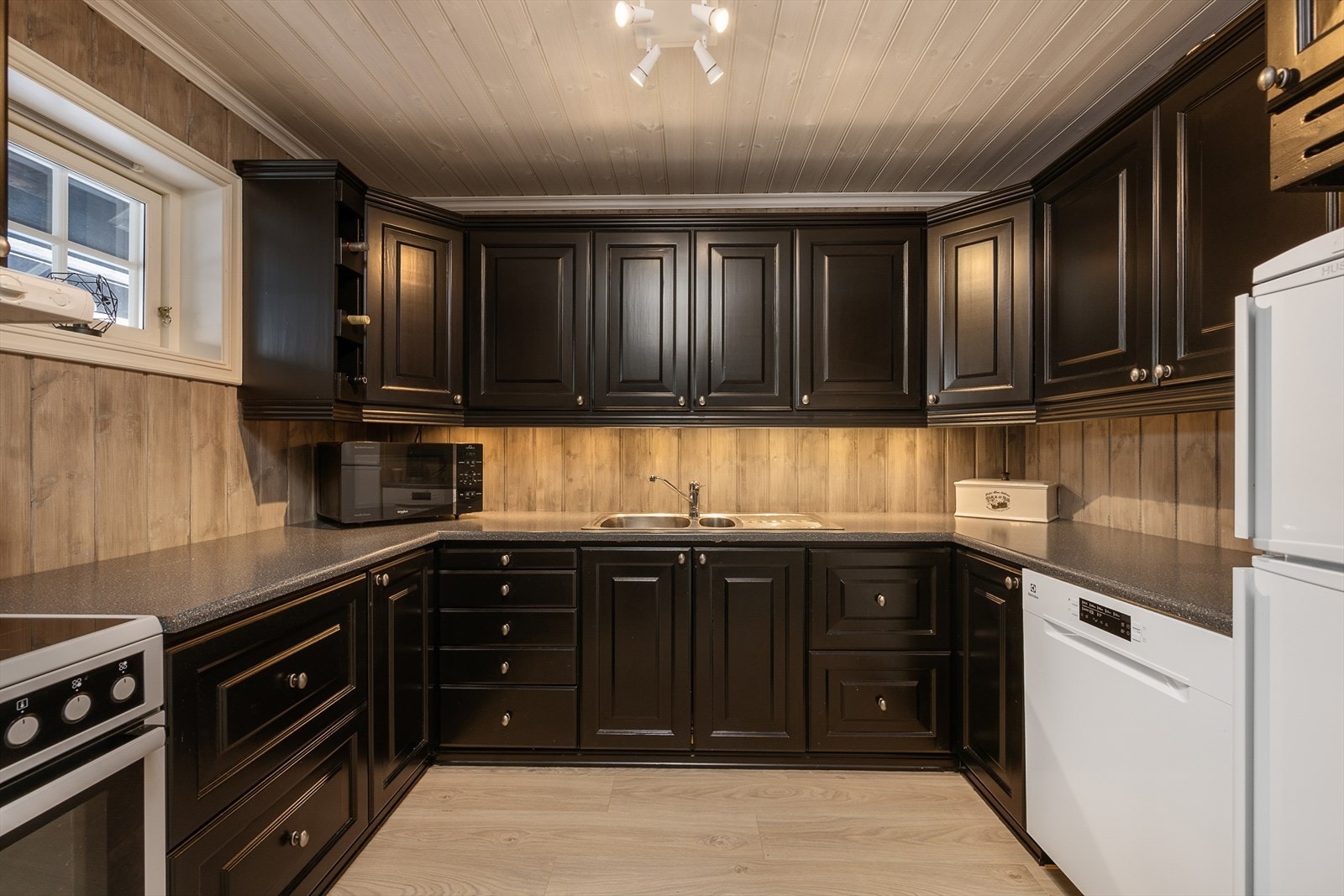 Kjøkkenet er i heltre og malt i en tidsriktig svart farge. U-formet innredning som gir rikelig med benke- og lagringsplass. Galleribilde