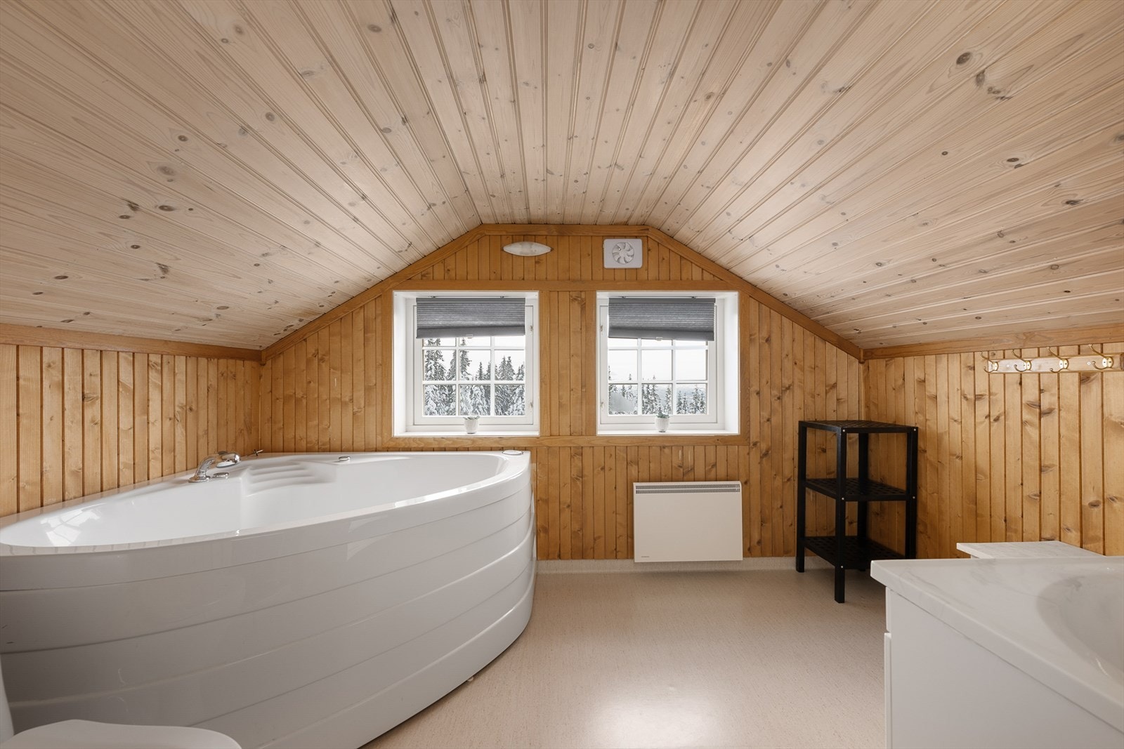 Badet på hemsen er innredet med et romslig hjørnebadekar for ekstra velvære. Galleribilde