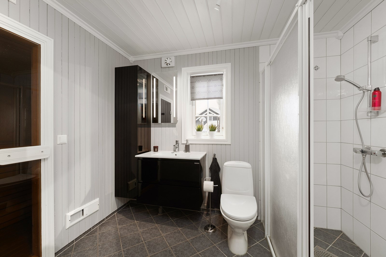 Badet i første etasje er utstyrt med dusjhjørne, toalett og servant med oppbevaring. Oppgradert med nyere innredning. Stilrent og tidløst. Galleribilde