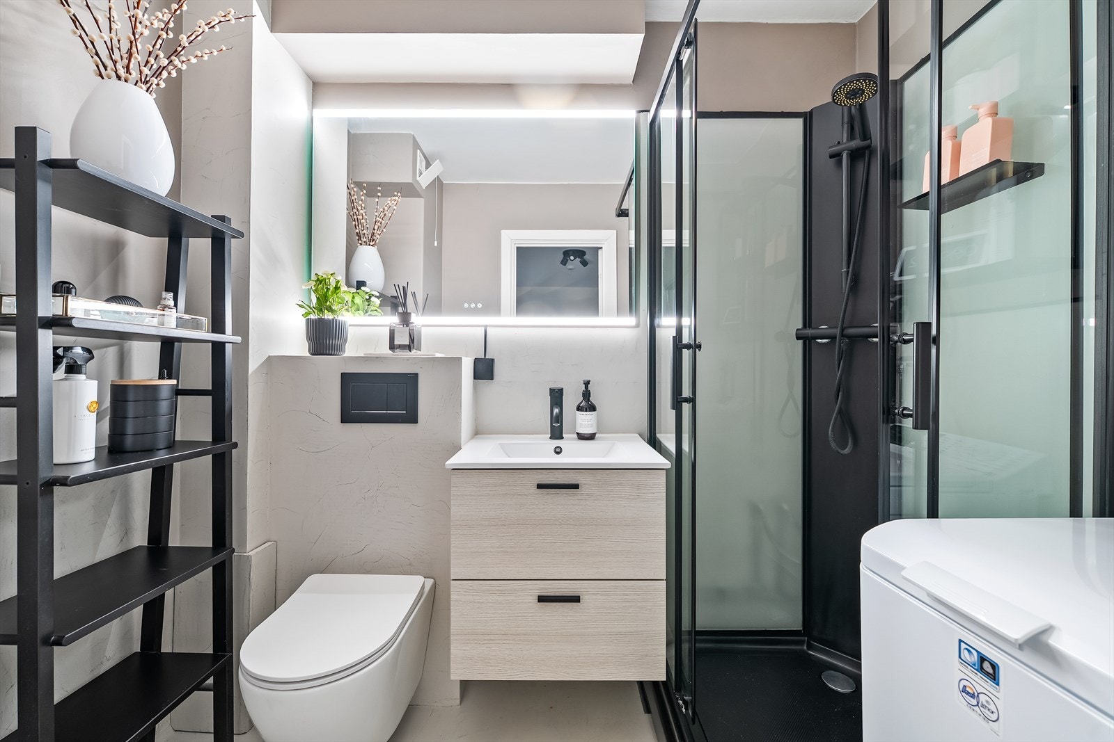 Pent og moderne bad med mørke kontraster i innredningen. Badet ble overflateoppusset i 2022 med mikrosement på gulv og vegger. Galleribilde