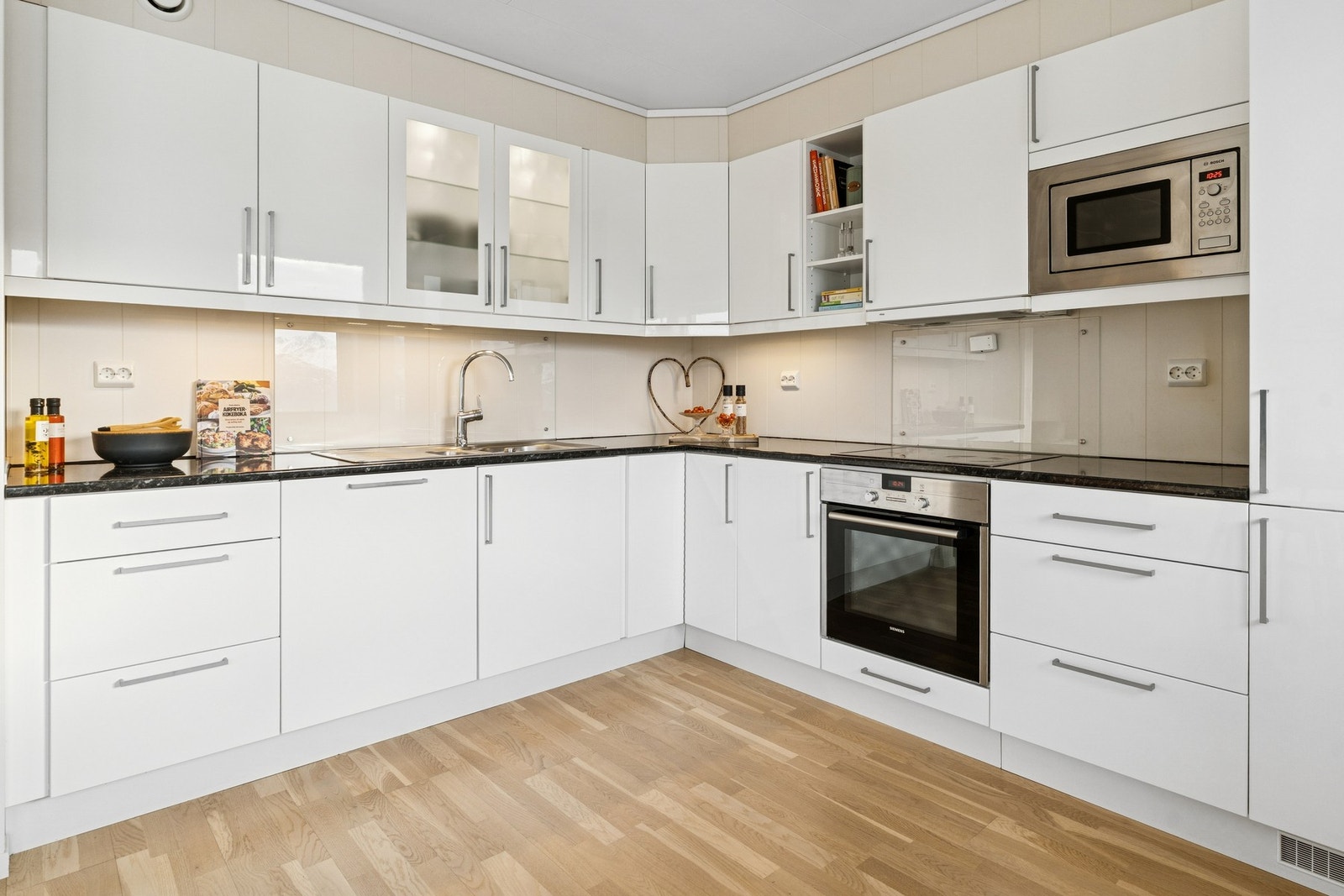 Stilrent kjøkken med integrerte hvitevarer og rikelig med skap- og benkeplass. Galleribilde