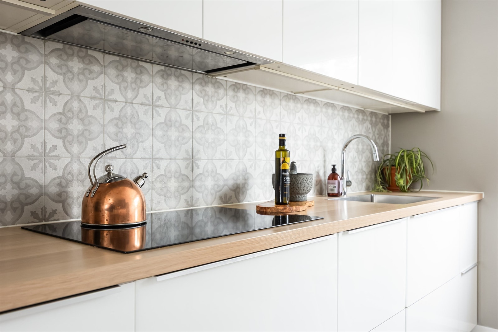 Kjøkkenet har laminat benkeplater, flislagt vegg over benk og benkeskapbelysning. Galleribilde