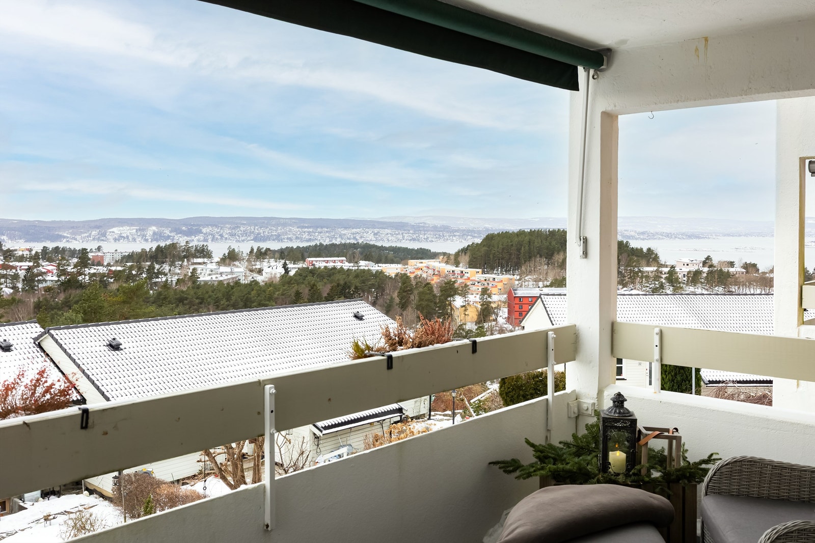 Balkongen har betonggulv belagt med plastheller, rekkverk i treverk og betong samt montert belysning og stikkontakter på vegg. Galleribilde