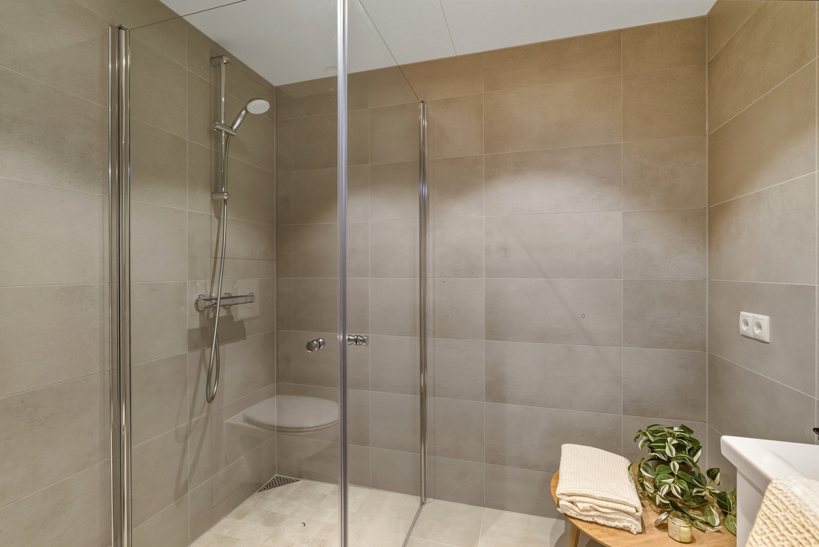 Moderne og tiltalende flislagt bad med 60x60 fliser på gulvet med vannbåren varme. Galleribilde