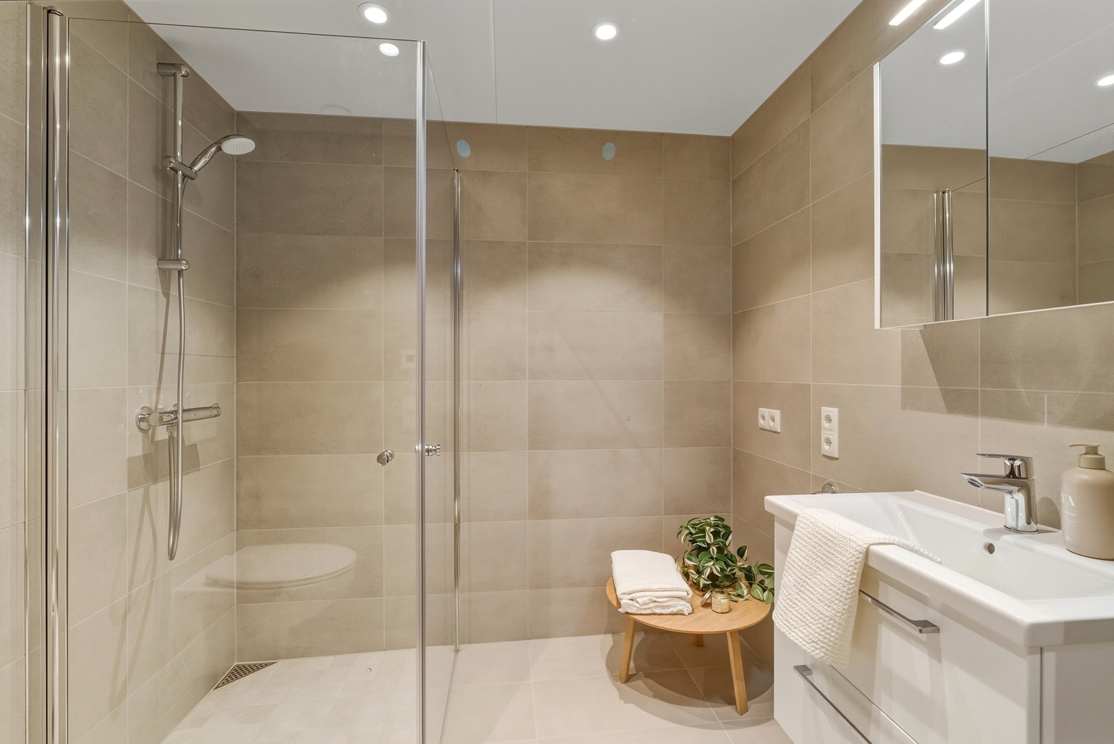 Moderne og tiltalende flislagt bad med 60x60 fliser på gulvet med vannbåren varme. Galleribilde